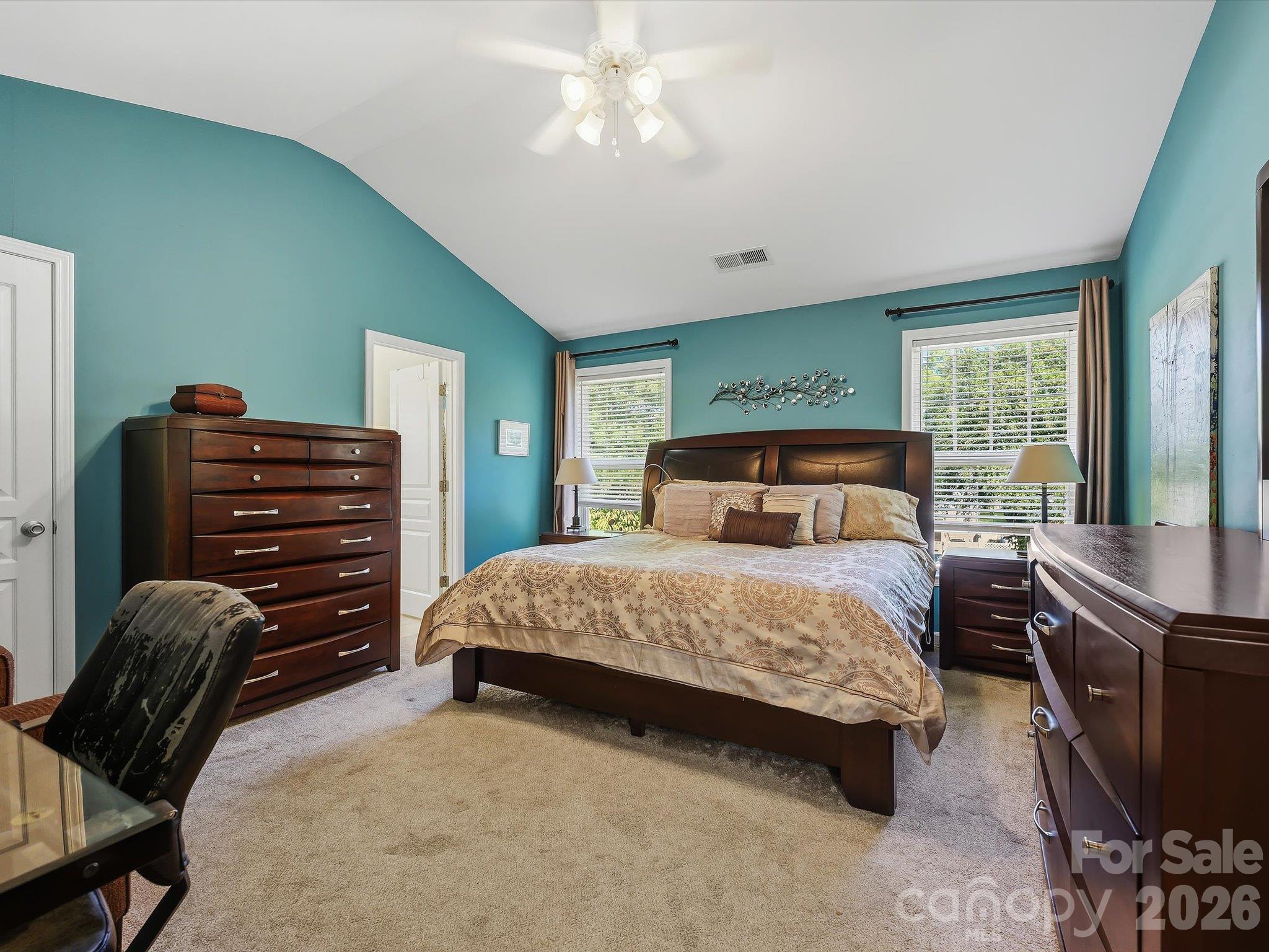 The spacious Primary Suite on the upper level features a vaulted ceiling, abundant natural light, and generous room for a comfortable private retreat. - 11732 Windy Mist Way, Huntersville