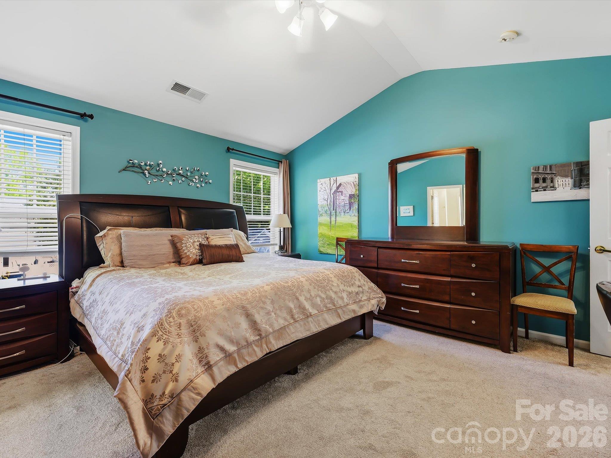 The spacious Primary Suite on the upper level features a vaulted ceiling, abundant natural light, and generous room for a comfortable private retreat. - 11732 Windy Mist Way, Huntersville