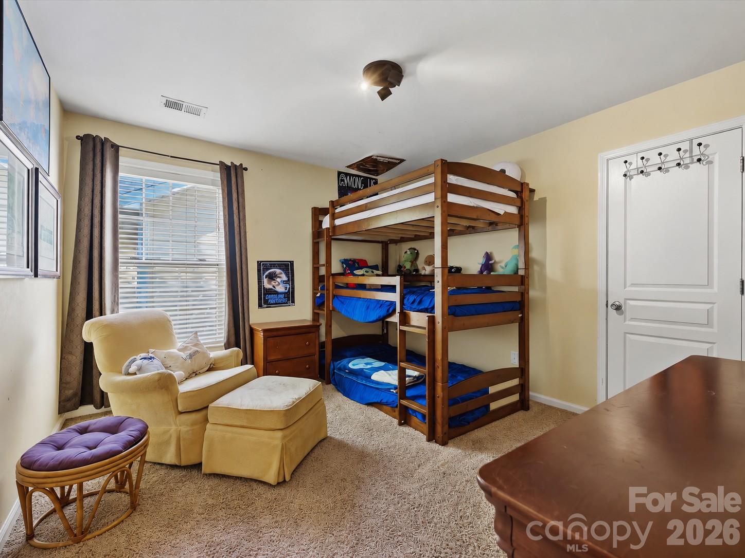 Bedroom 2 offers a comfortable layout with abundant natural light, neutral carpeting, and generous space for bedroom furnishings. - 11732 Windy Mist Way, Huntersville