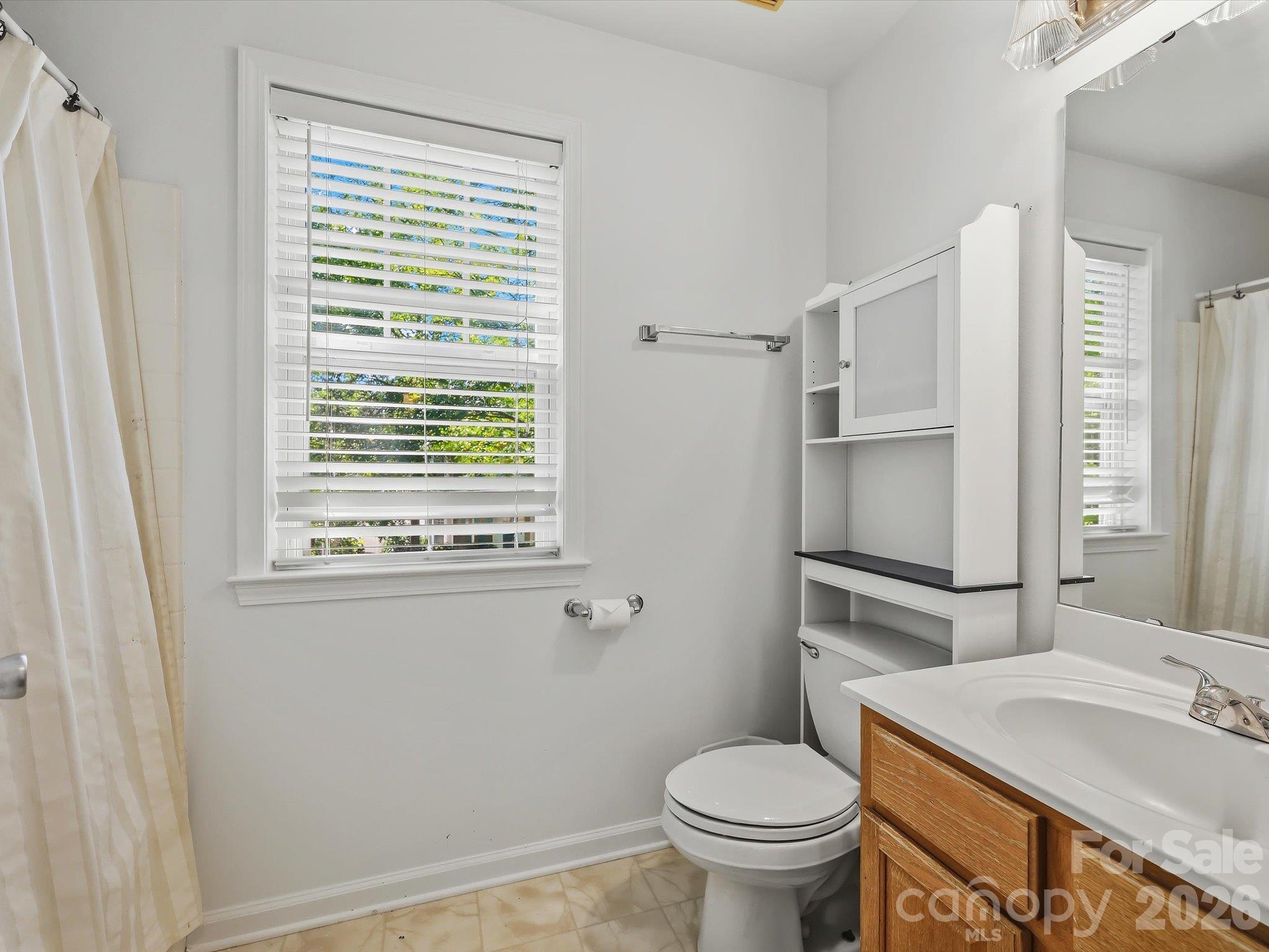 The full bath features a spacious vanity, tub/shower combination and natural light from a large window. - 11732 Windy Mist Way, Huntersville