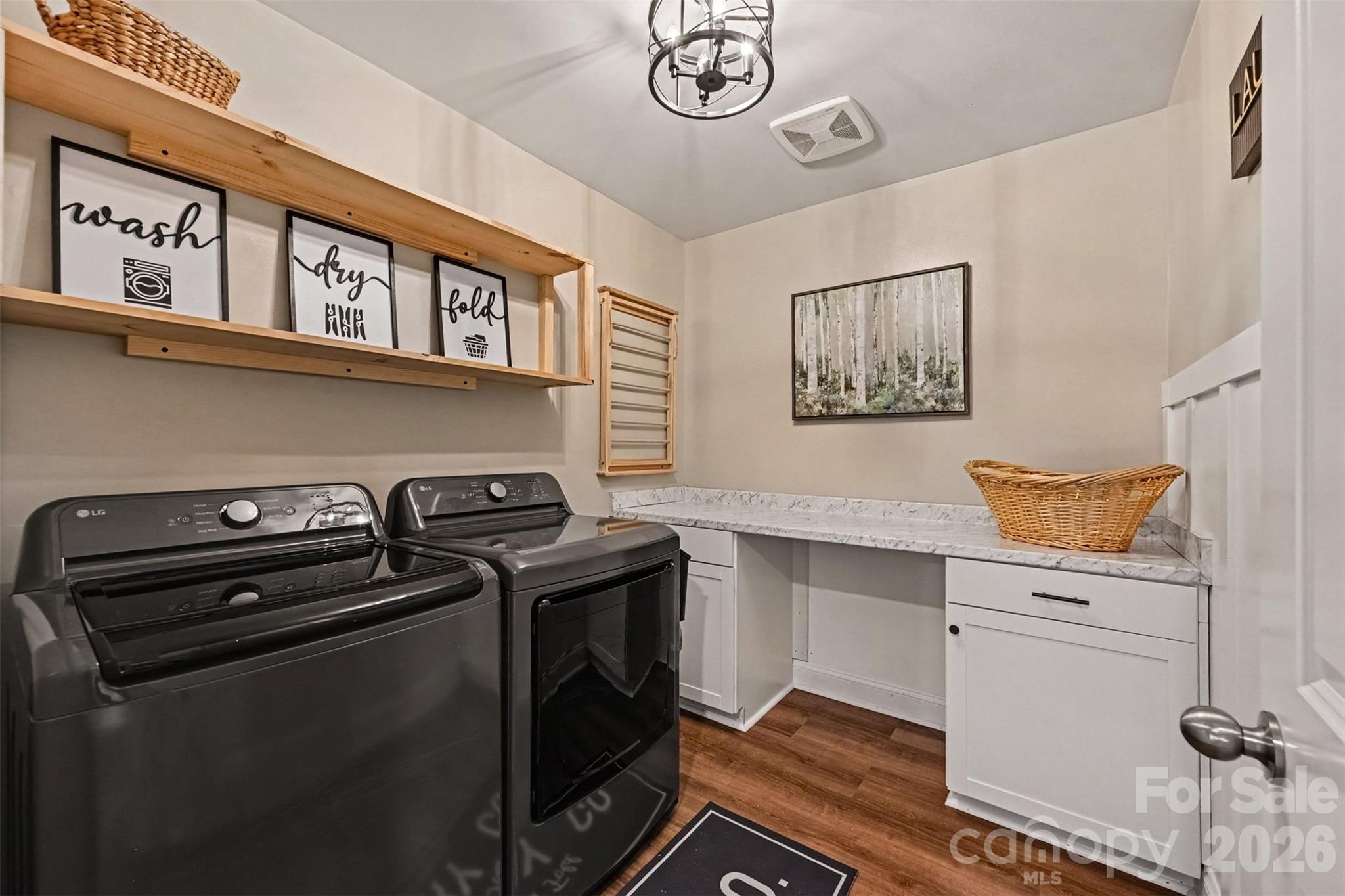 A laundry room with a built-in folding counter and shelving, so laundry day hurts a little less. - 2703 Wedgewood Court, Denver