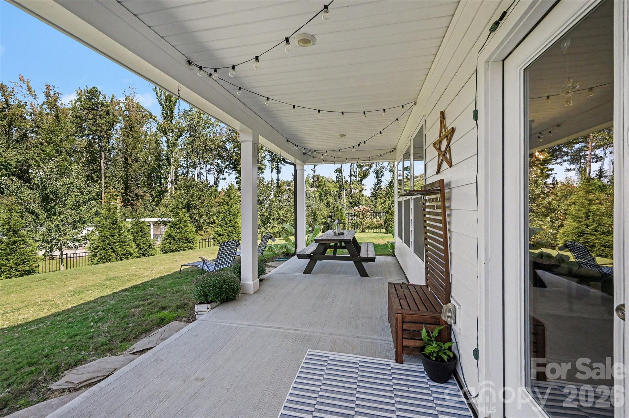 A long covered back porch with string lights, ready for evenings outside. - 2703 Wedgewood Court, Denver