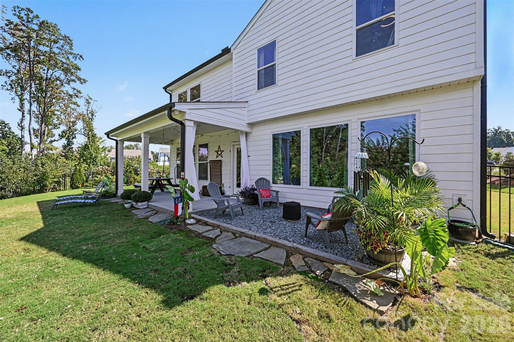 A spacious backyard with a covered porch and landscaped beds. - 2703 Wedgewood Court, Denver
