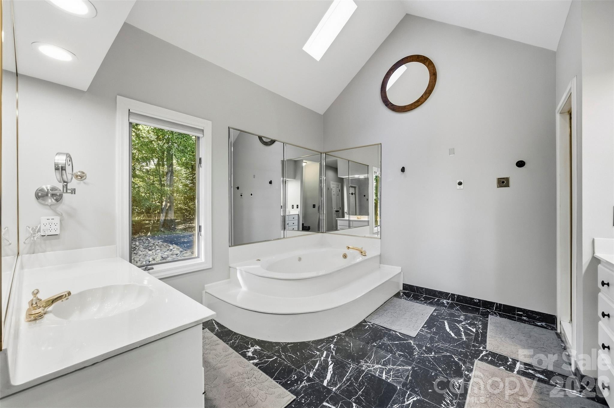 Vaulted ceiling primary bathroom has a huge whirlpool tub... - 185 Appian Way, Shelby