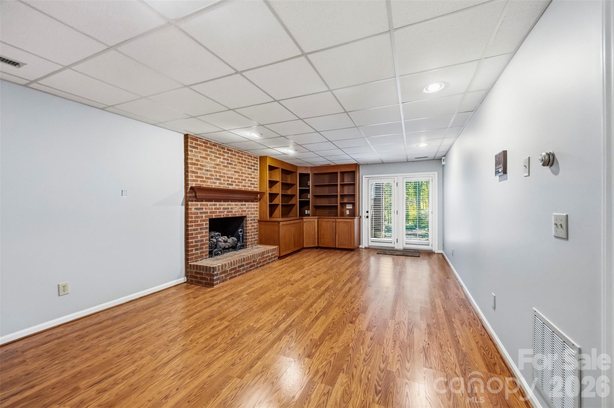 Additional den in the basement with French doors leading to the back yard. Gas log fireplace and wet bar (not pictured) - 185 Appian Way, Shelby