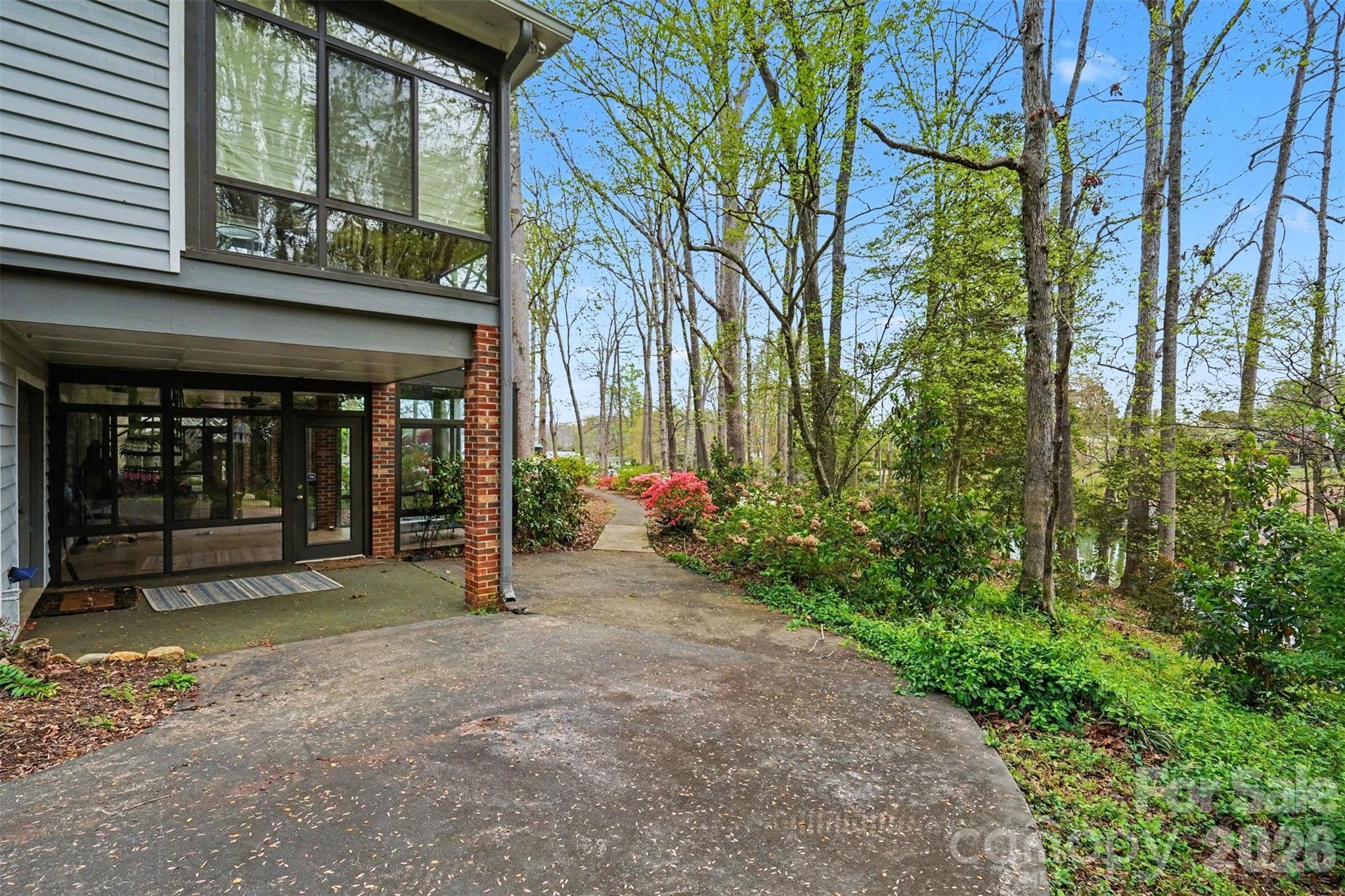 Side view shows door to sunroom as well as the access door to basement storage area--so much space for all of your water toys! - 185 Appian Way, Shelby