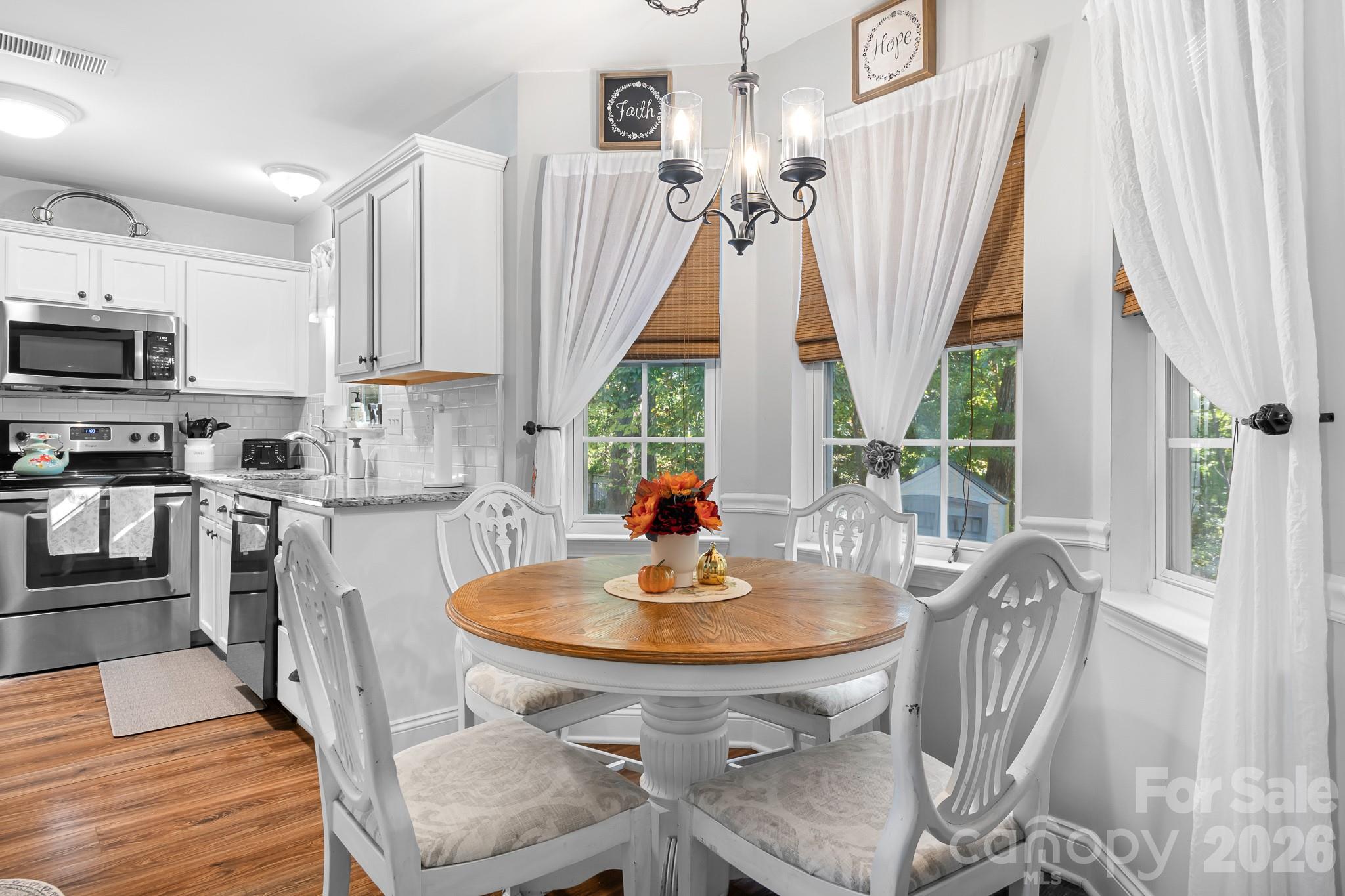 Breakfast table area with Bay window overlooking backyard and woods. Perfect for Coffee with Friends or a game of cards! - 4126 Medford Drive NW, Concord