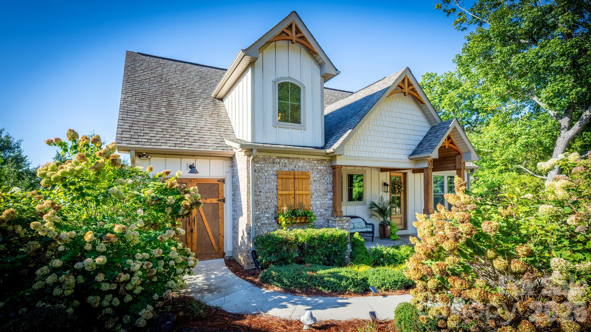 From the moment you arrive, the home's distinctive architecture, handsome timber accents, inviting covered entry, and beautifully manicured landscaping create an unforgettable first impression. - 1285 Saunders Drive, Catawba