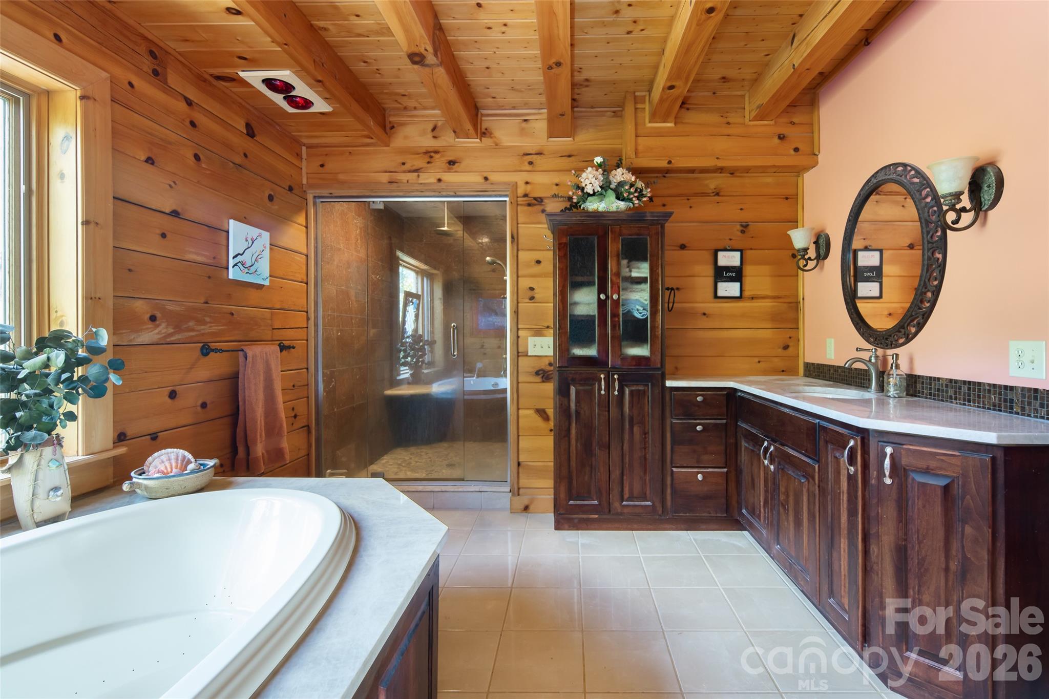 Primary bathroom on the main level with a garden tub and walk-in shower. - 316 Stevenson Cove Road, Waynesville