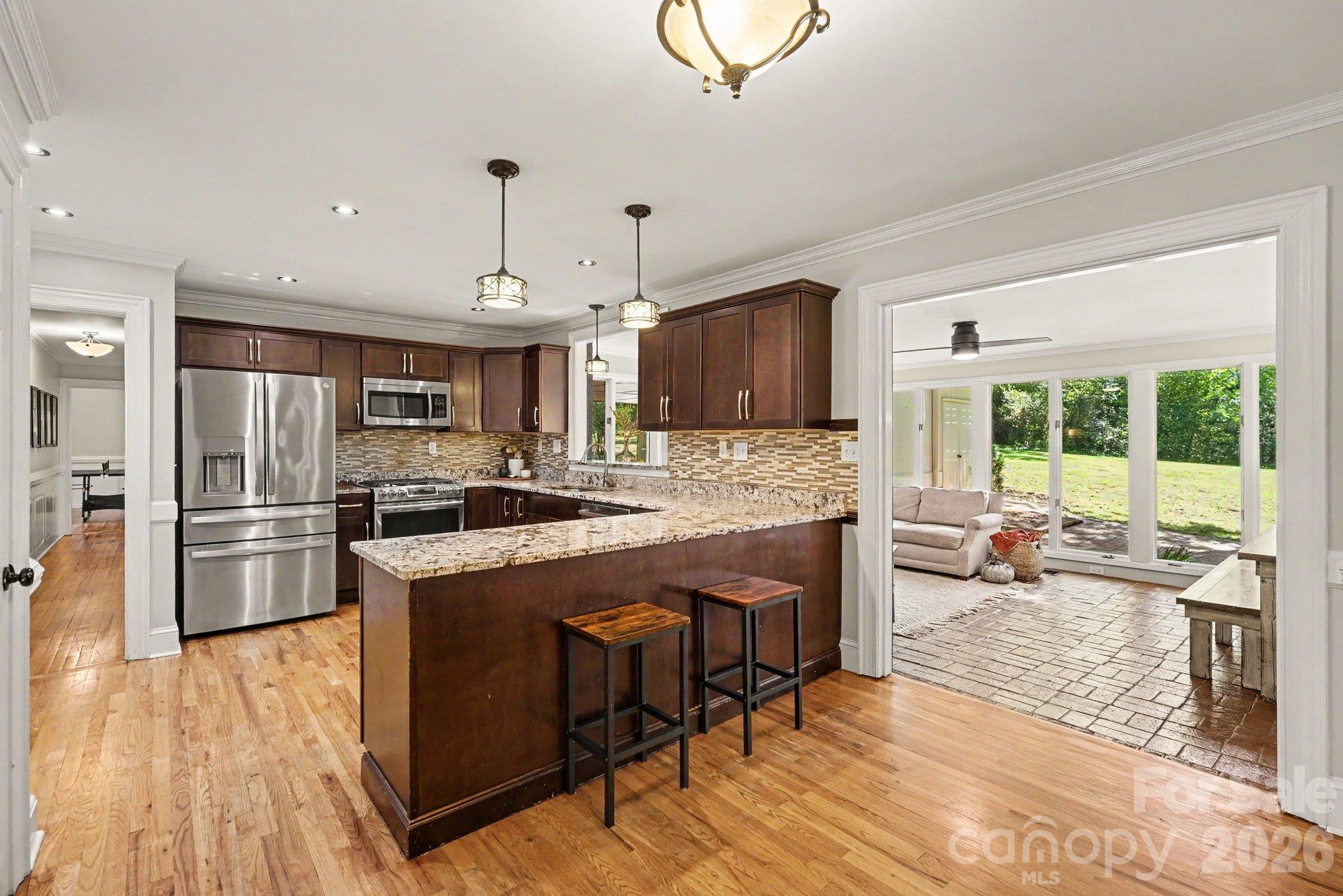 Rich cabinetry, stainless steel appliances, and a spacious breakfast bar complement a kitchen that opens to a bright sunroom. - 607 Anderson Avenue, Salisbury