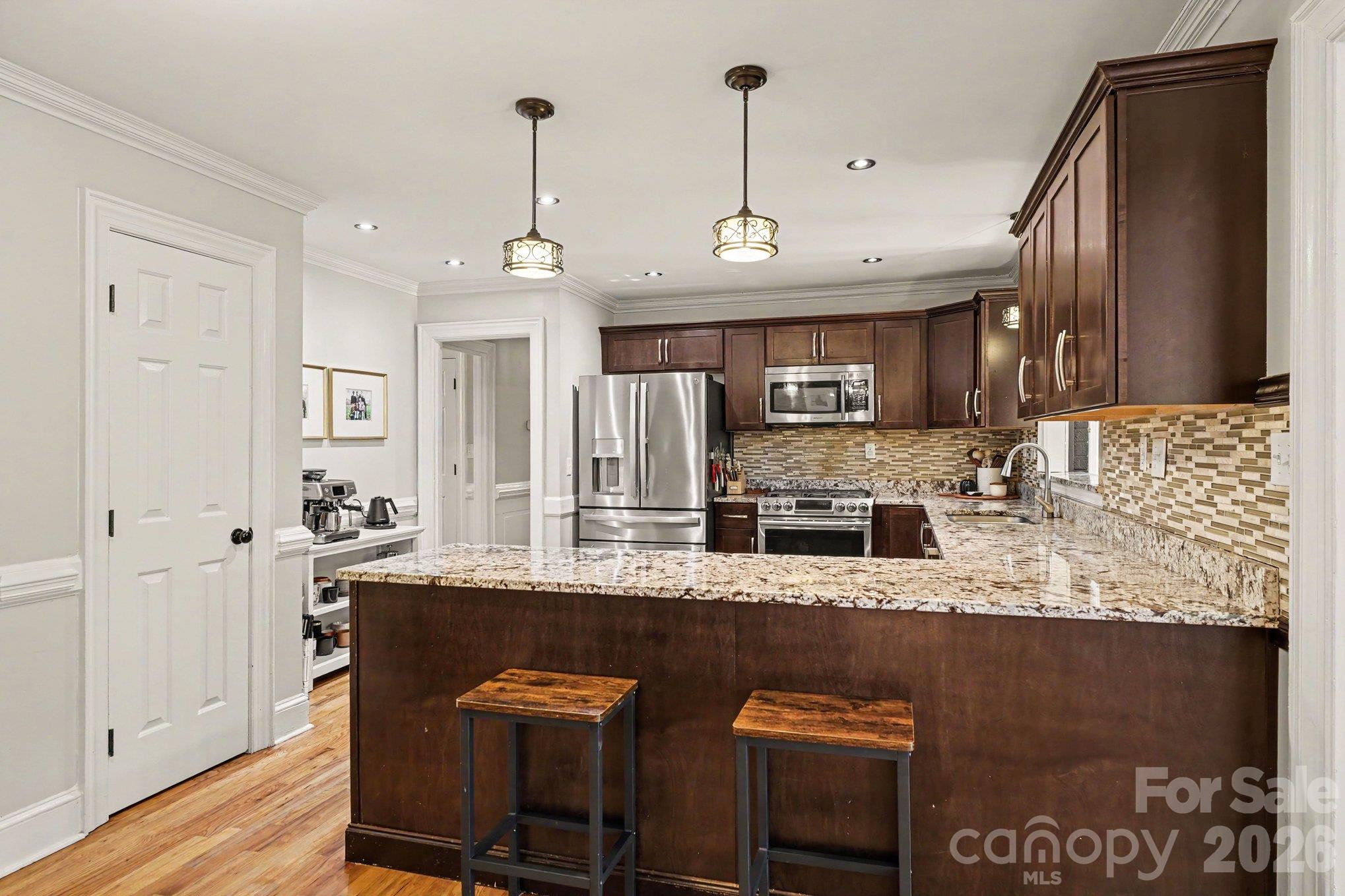Granite countertops and recessed lighting enhance the kitchen, while a convenient pantry provides additional storage - 607 Anderson Avenue, Salisbury