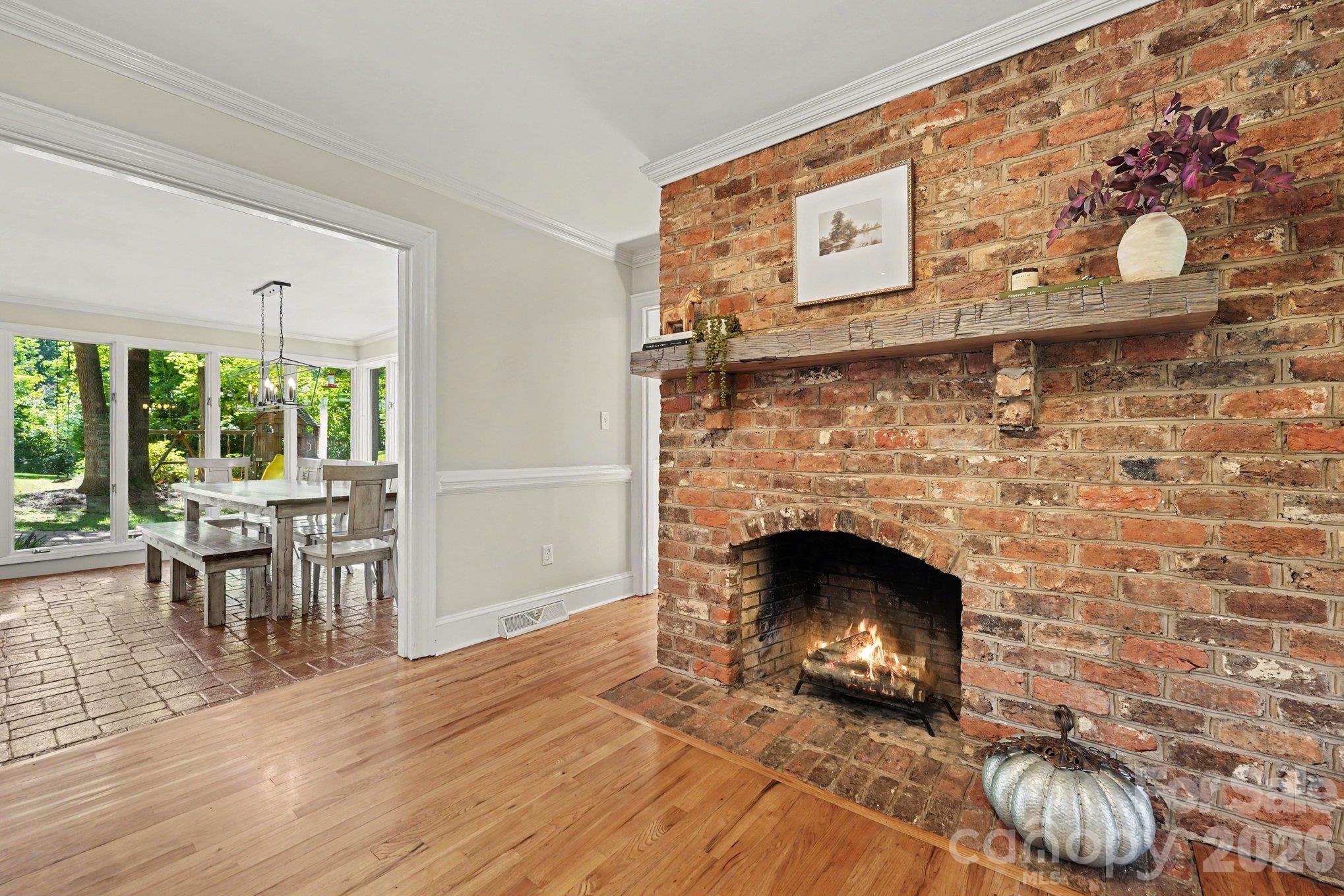 A striking brick fireplace adds character and charm to the kitchen, with access to the stunning sunroom just beyond - 607 Anderson Avenue, Salisbury