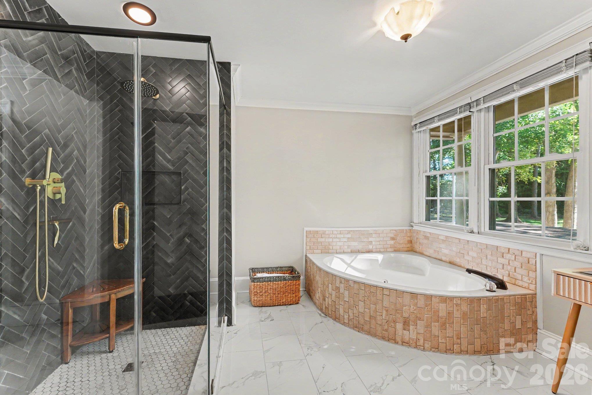 Spacious en-suite bath featuring an updates walk in shower and a soaking tub beneath a large window - 607 Anderson Avenue, Salisbury