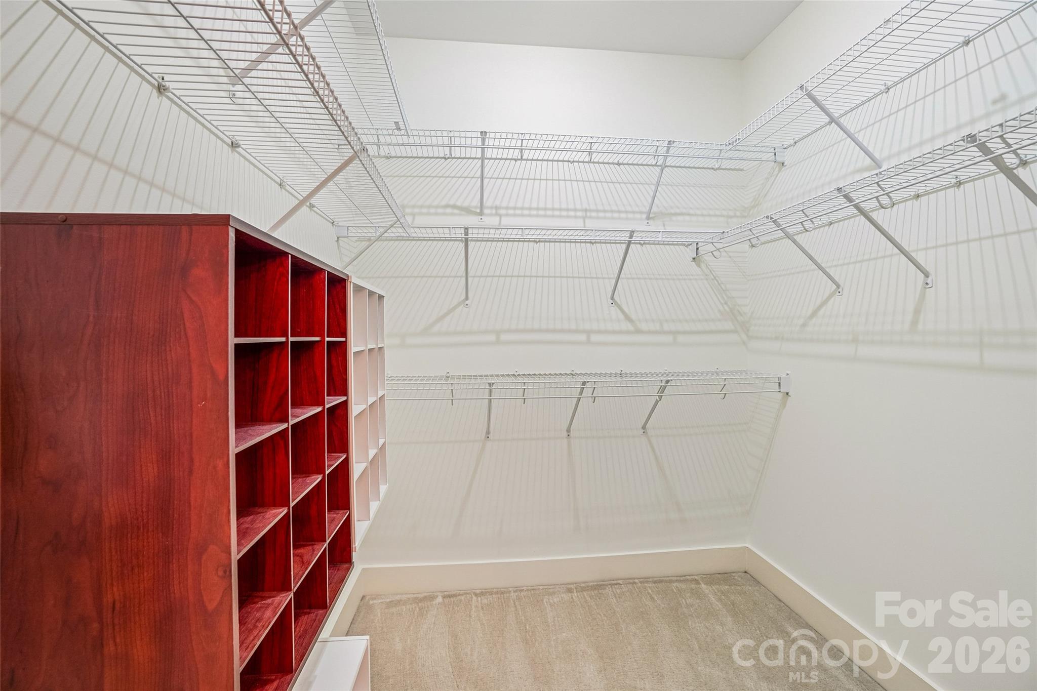 Walk-in-closet in primary has lots of room for hanging clothes and added shoe storage. - 9 Kenilworth Knolls, Asheville