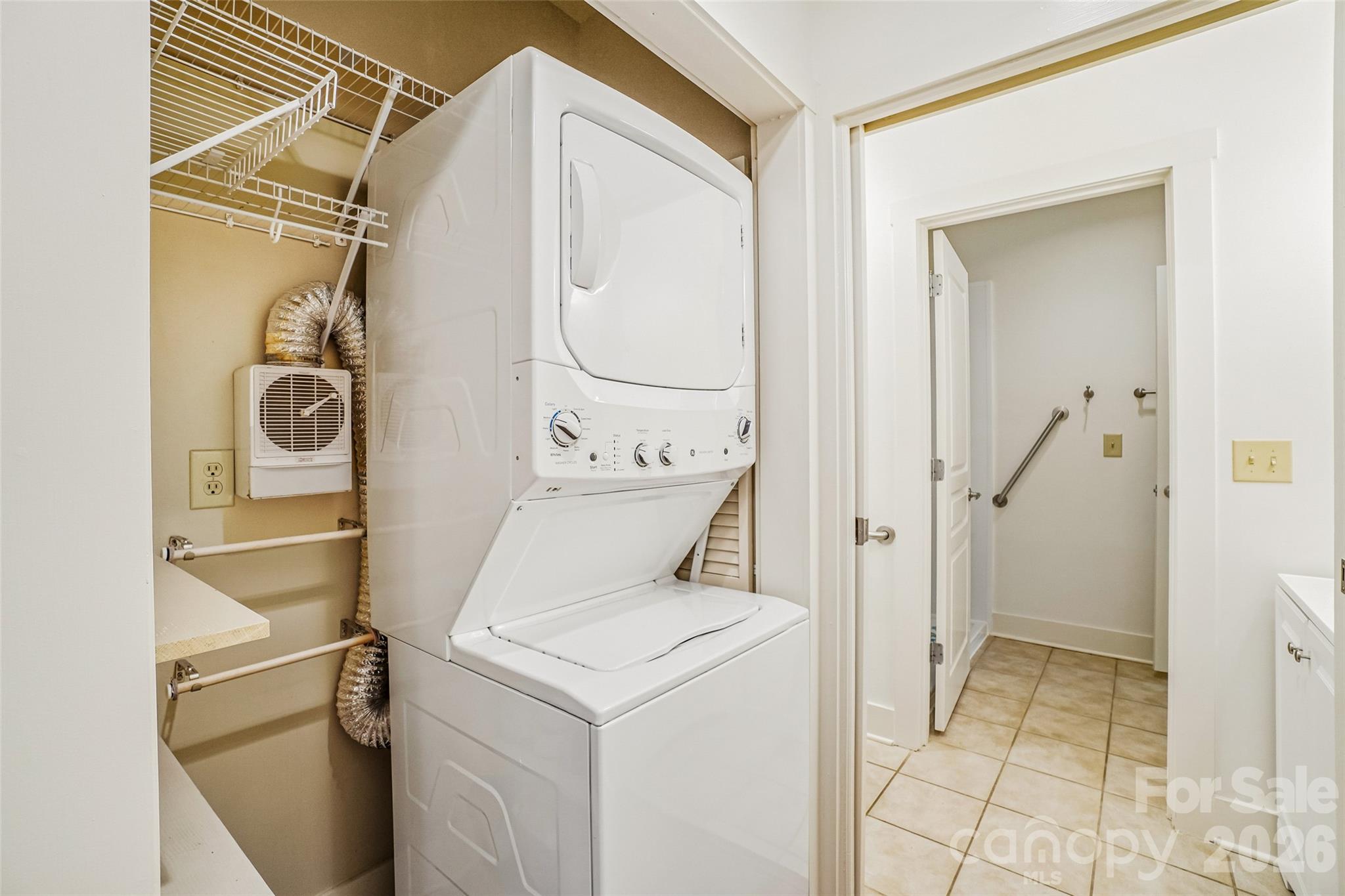 Stacked laundry closet has doors removed and shelves for extra storage and easy access. - 9 Kenilworth Knolls, Asheville