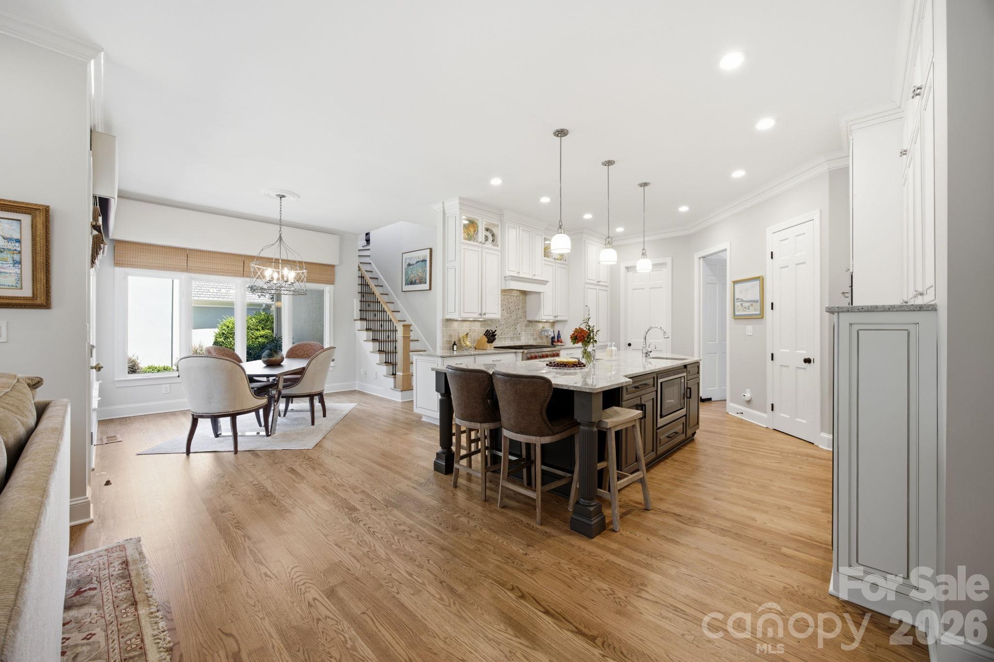 Gather and celebrate in this warm, open-concept living and dining space flooded with natural light. - 18416 Peninsula Club Drive, Cornelius