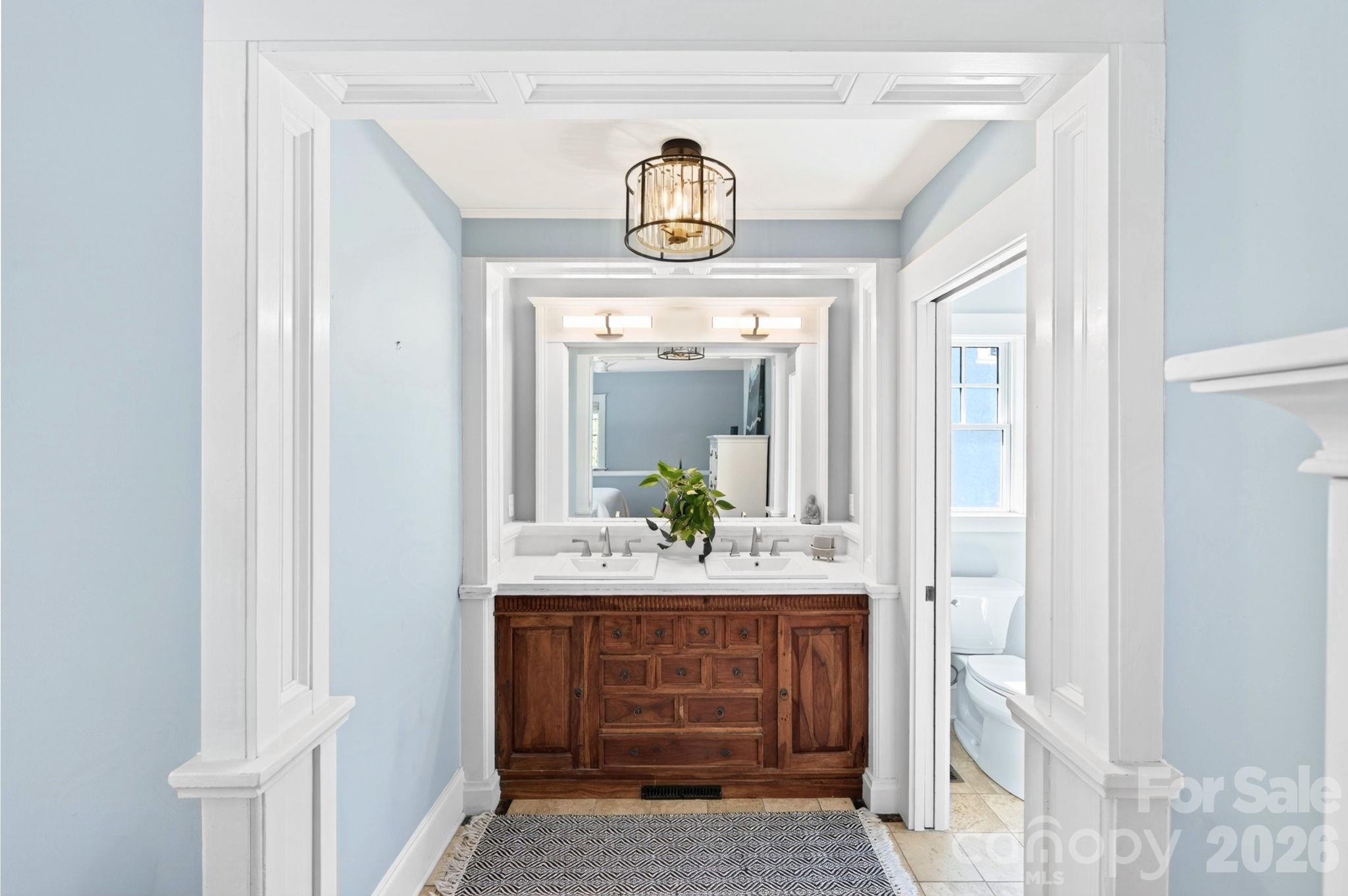 Rich Mediterranean-Inspired Wood Vanity Framed by Elegant Architectural Millwork - 133 Furman Avenue, Asheville