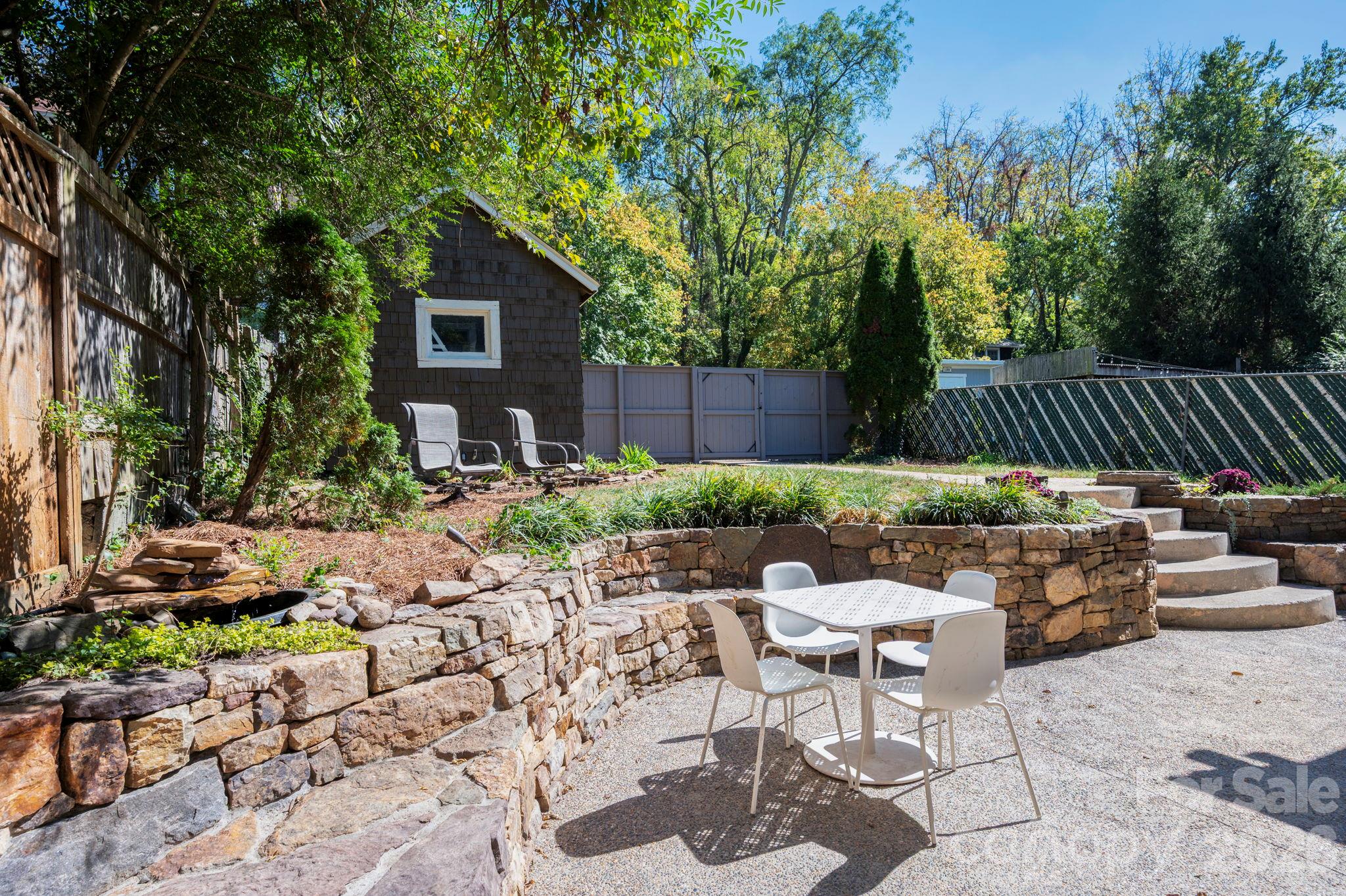 Pebbled-Concrete Patio and Stacked-Stone Retaining Wall with Built-In Seating - 133 Furman Avenue, Asheville