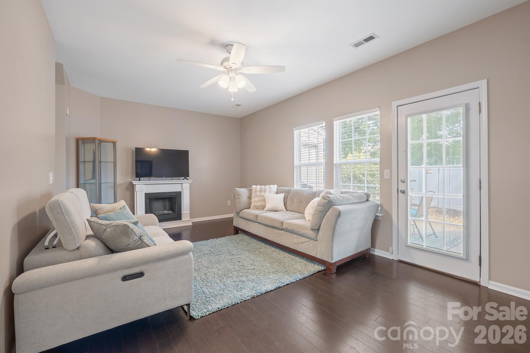 Living room with bamboo flooring and a door leading to the private back patio. - 4144 Kenton Glenn Court NW, Concord