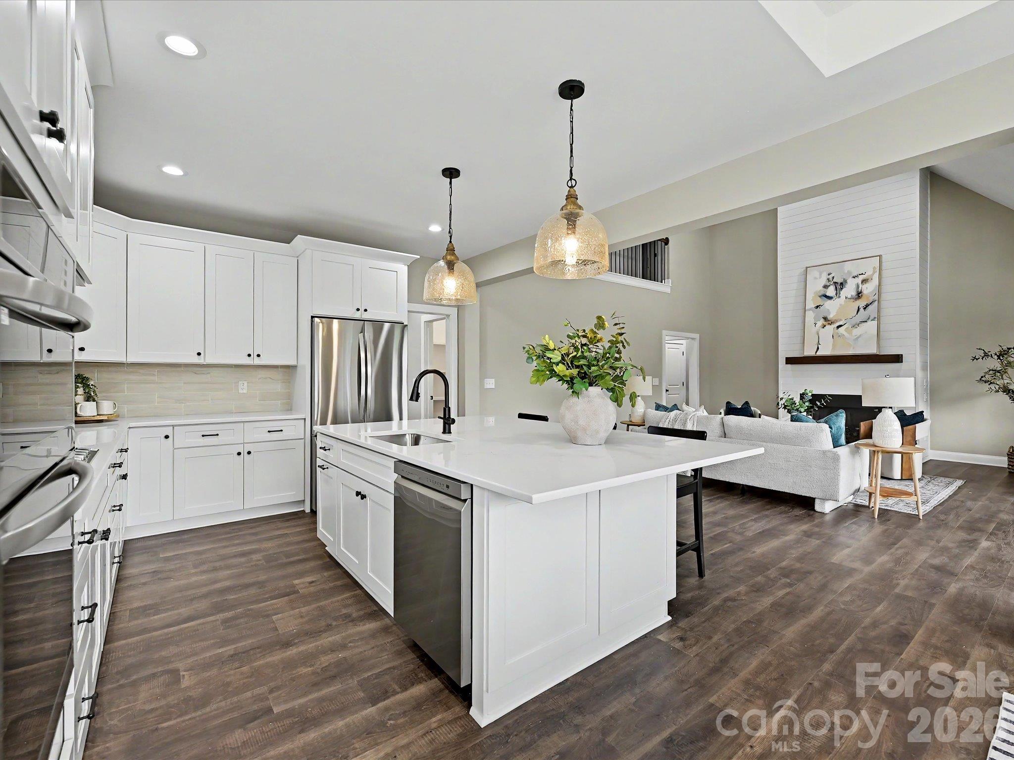 Designer kitchen features as massive quartz island, custom cabinetry, stainless steel appliances & an open layout perfect for everyday living & entertaining. - 159 Lone Pine Road, Statesville