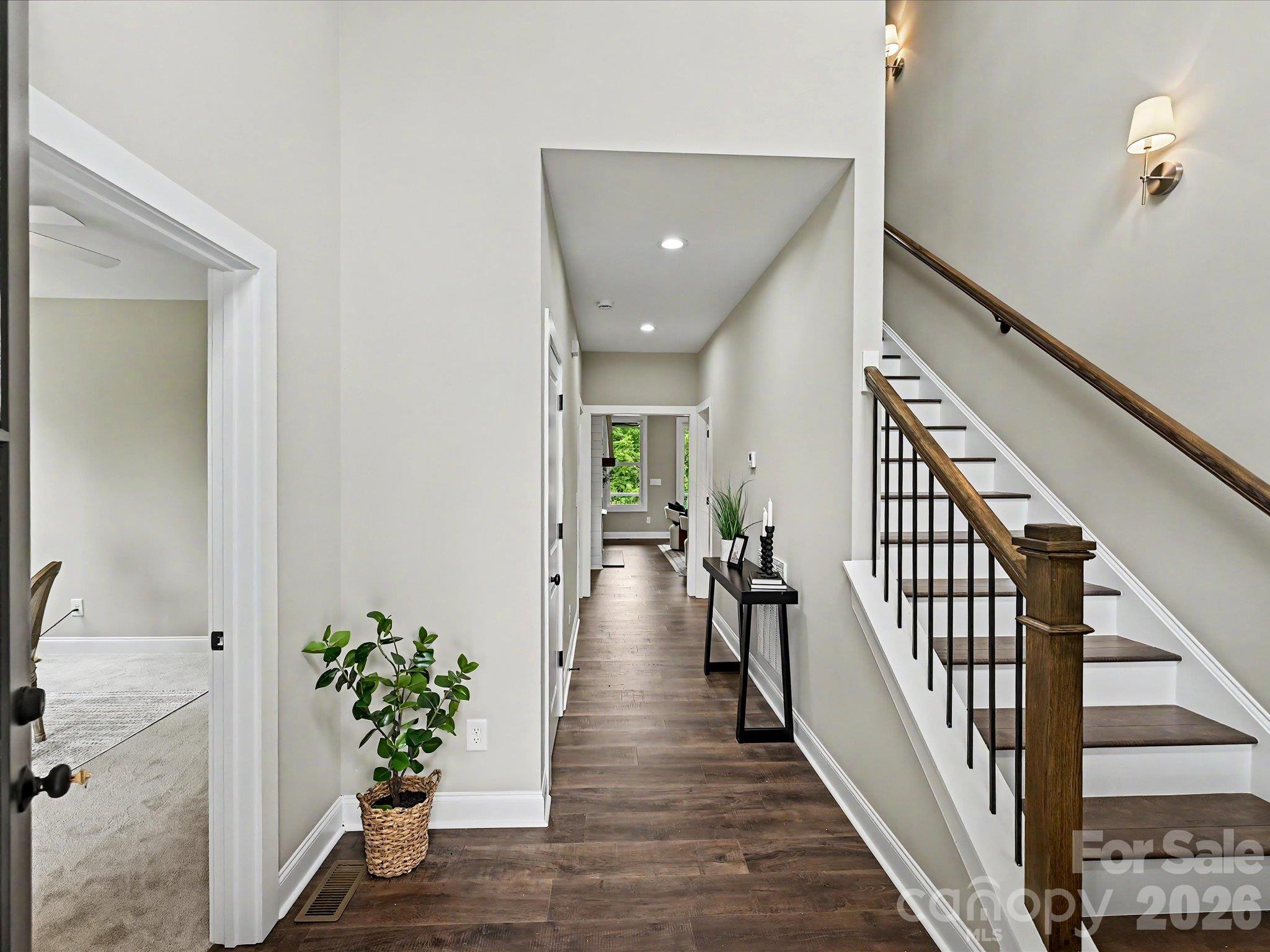 Step into this bright and inviting entryway featuring soaring ceilings, rich LVP floors & a stunning staircase that sets the tone for the home's modern design. - 159 Lone Pine Road, Statesville