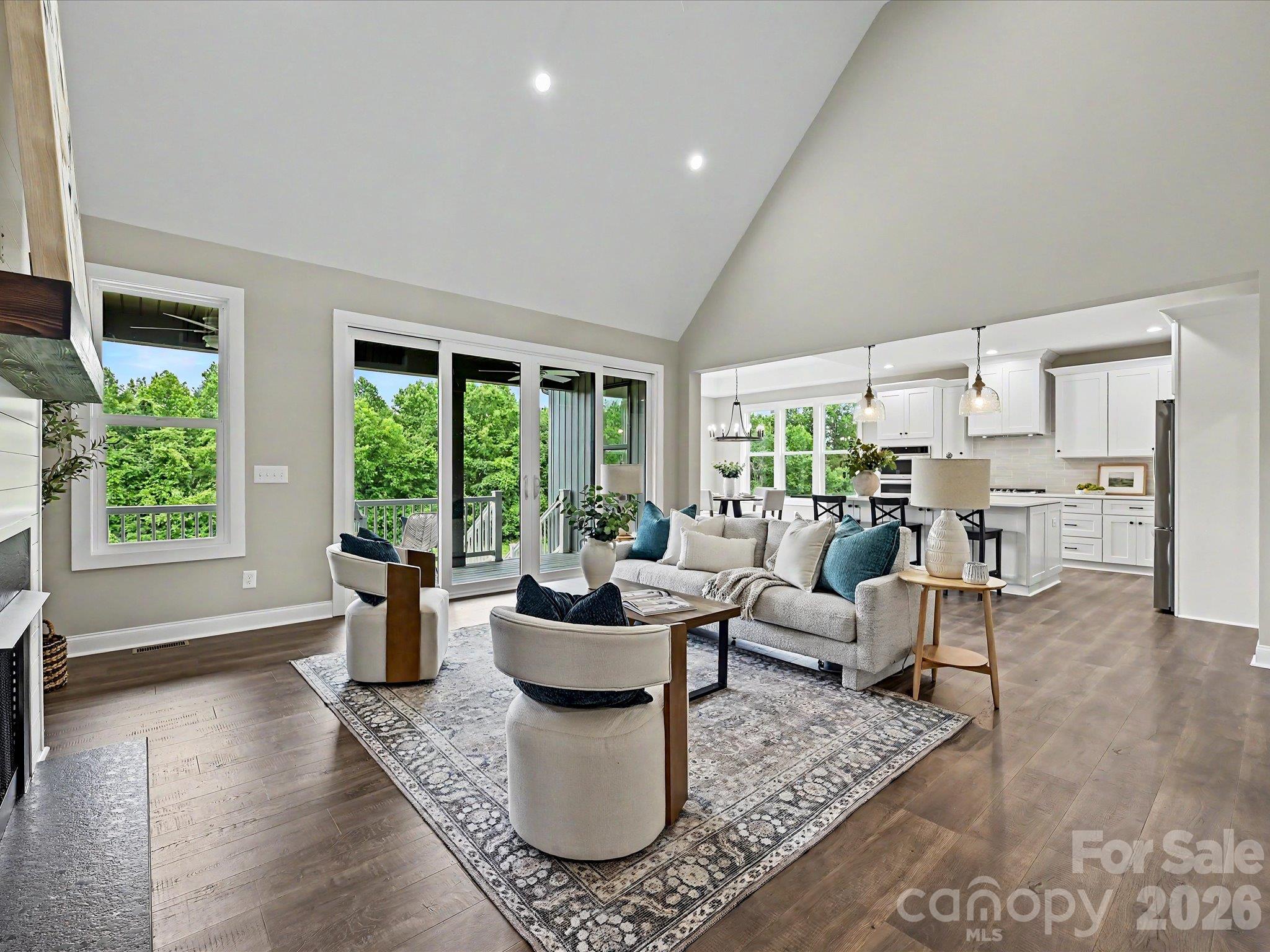 The stunning great room showcases soaring vaulted ceilings, expansive windows with scenic views, cozy gas fireplace & an open concept layout that seamlessly connects the living, dining & kitchen spaces for effortless entertaining. - 159 Lone Pine Road, Statesville