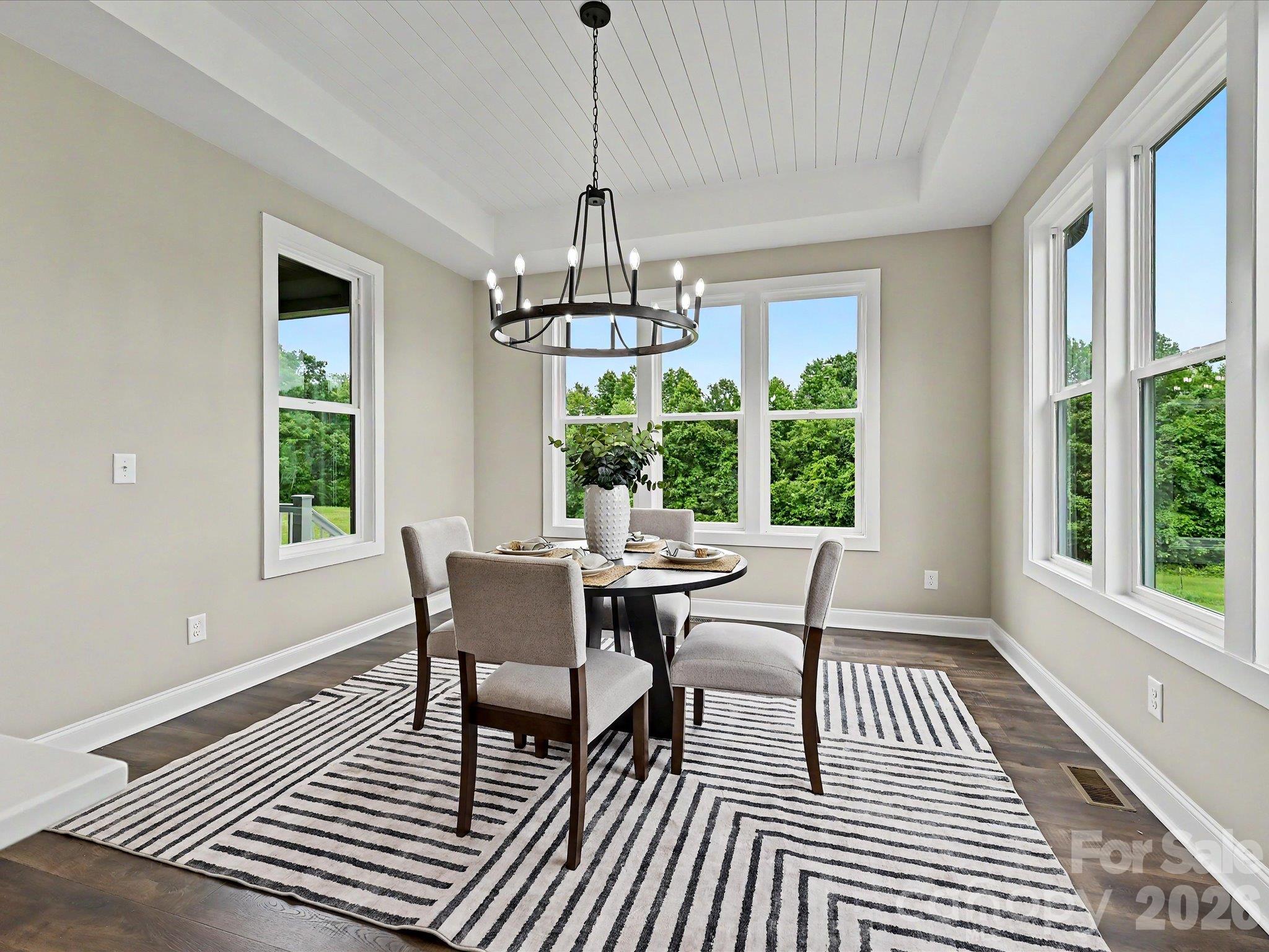 Elegant dining area offers a warm & inviting space to gather, highlighted by designer lighting, tray ceiling detail & seamless flow into the gourmet kitchen. - 159 Lone Pine Road, Statesville