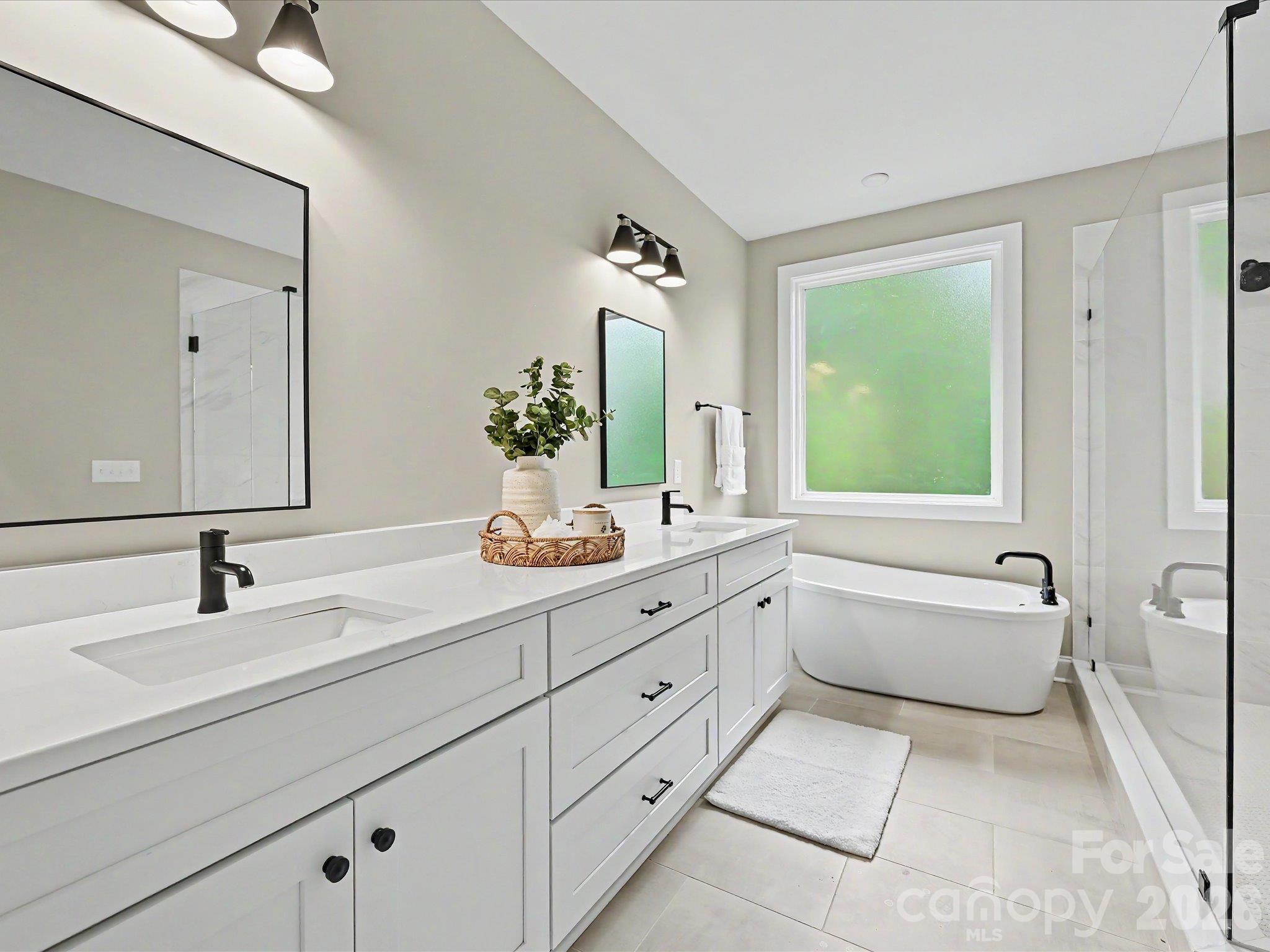 Luxurious primary bath offers a dual sink vanity, oversized walk in tile shower & relaxing freestanding soaking tub. - 159 Lone Pine Road, Statesville