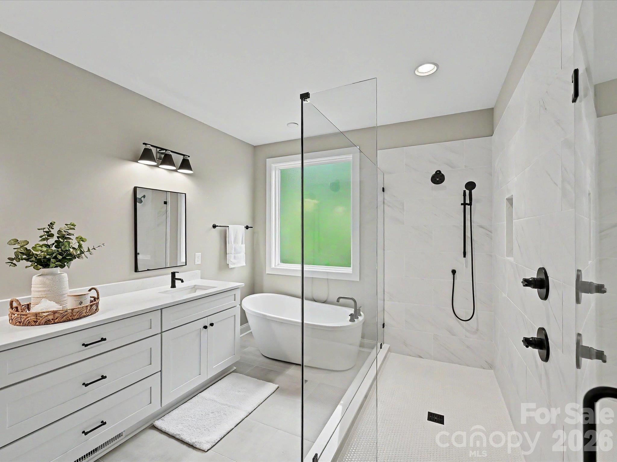Luxurious primary bath offers a dual sink vanity, oversized walk in tile shower & relaxing freestanding soaking tub. - 159 Lone Pine Road, Statesville