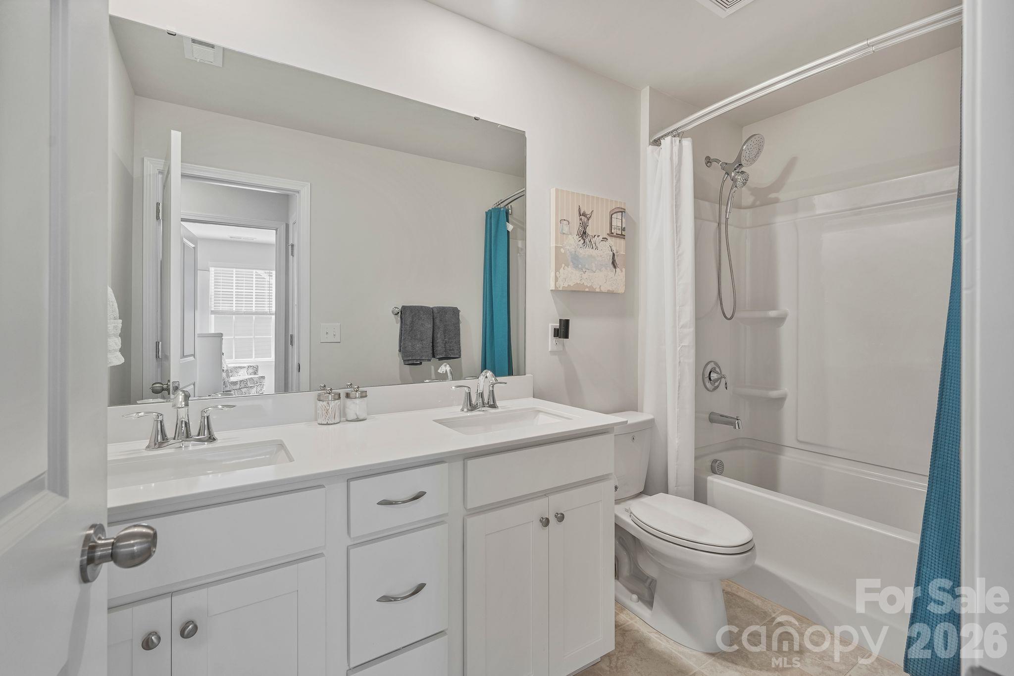 Spacious upstairs full bathroom featuring double vanities, conveniently shared between the third and fourth bedrooms. - 107 Hollywood Court, Troutman