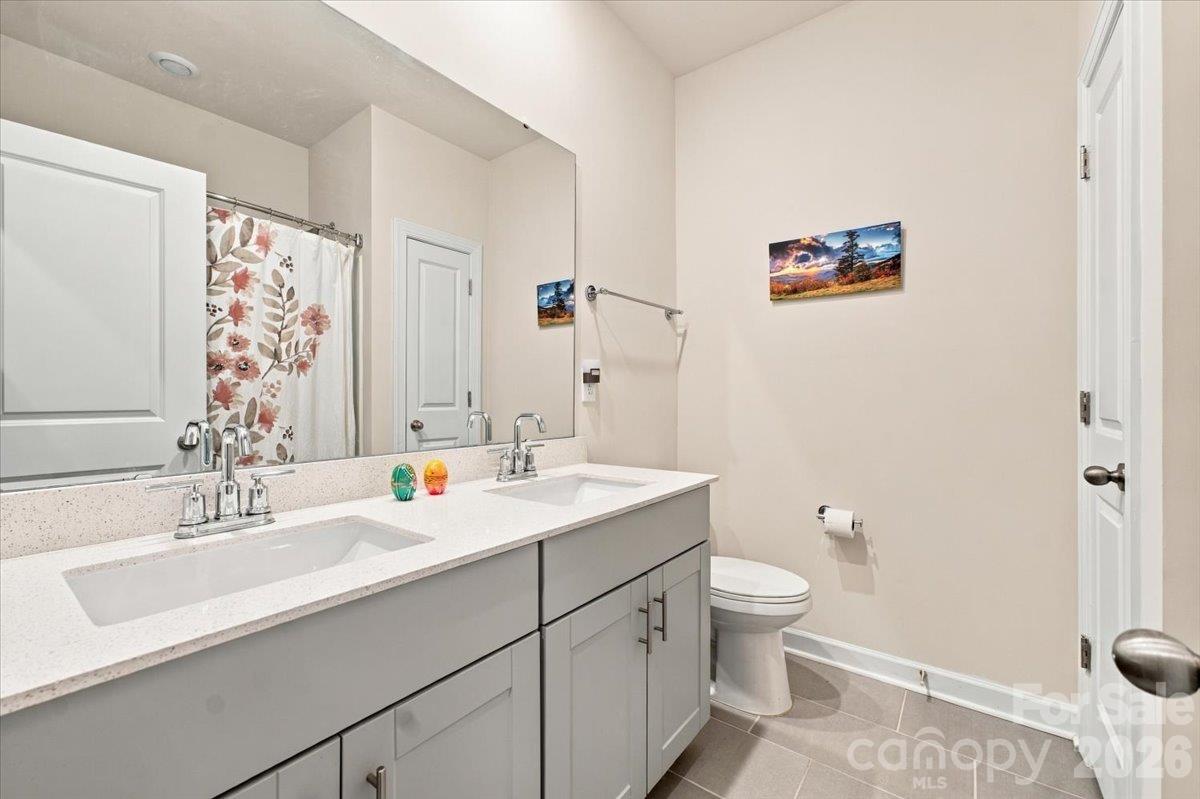Shared bath with a dual sink vanity & storage. - 7722 Porrera Street, Charlotte