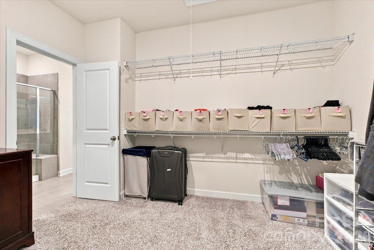 Primary closet with access to the primary bath & laundry room. - 7722 Porrera Street, Charlotte