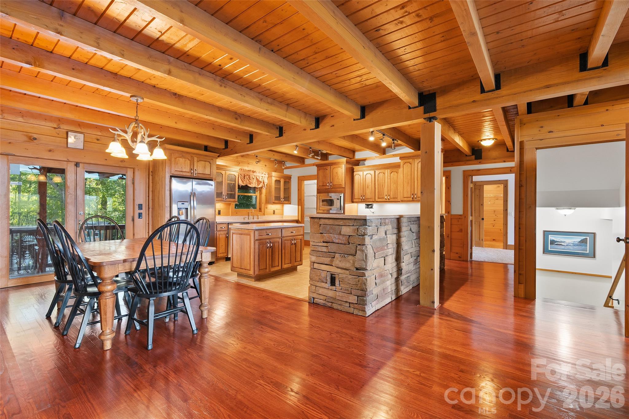 Open-concept dining and kitchen areas showcase the home's rustic craftsmanship. - 124 Borges Lane, Waynesville