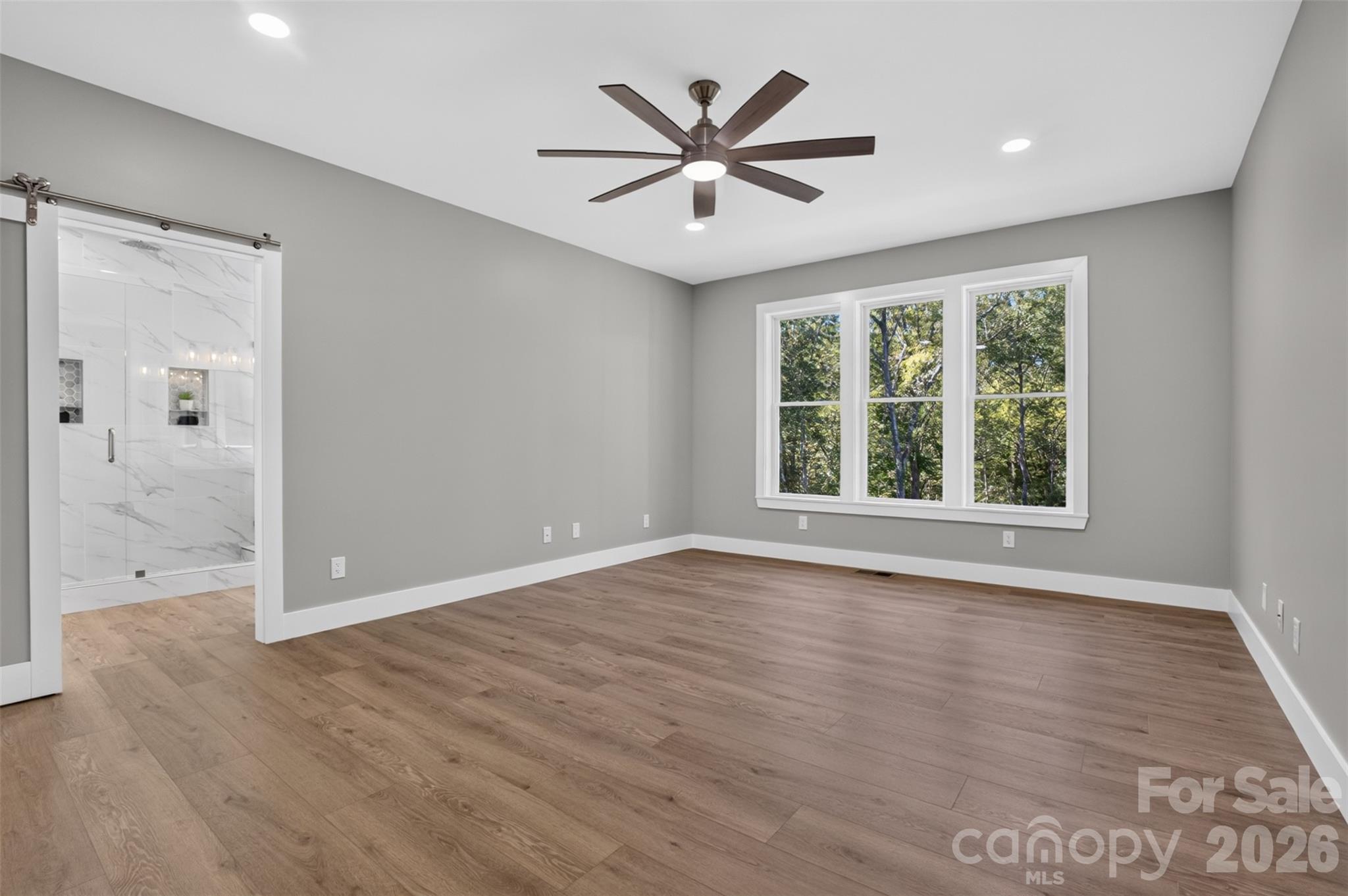 Primary bedroom ensuite with glass barn door and overlooking the lovey backyard. - 160 Pumice Drive, Statesville