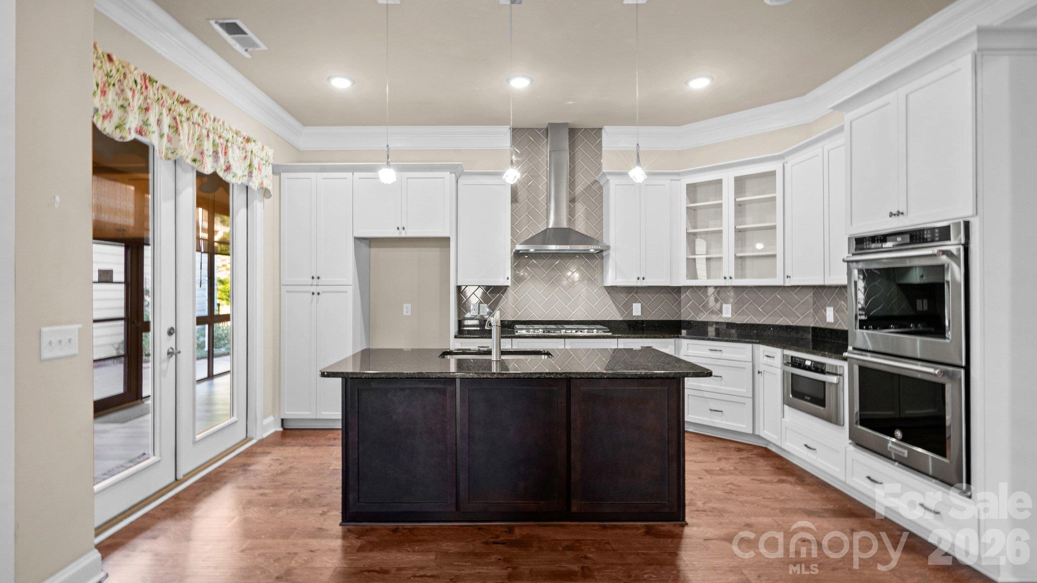 Kitchen with large island, granite counters and double wall ovens - 2050 Laney Pond Road, Matthews
