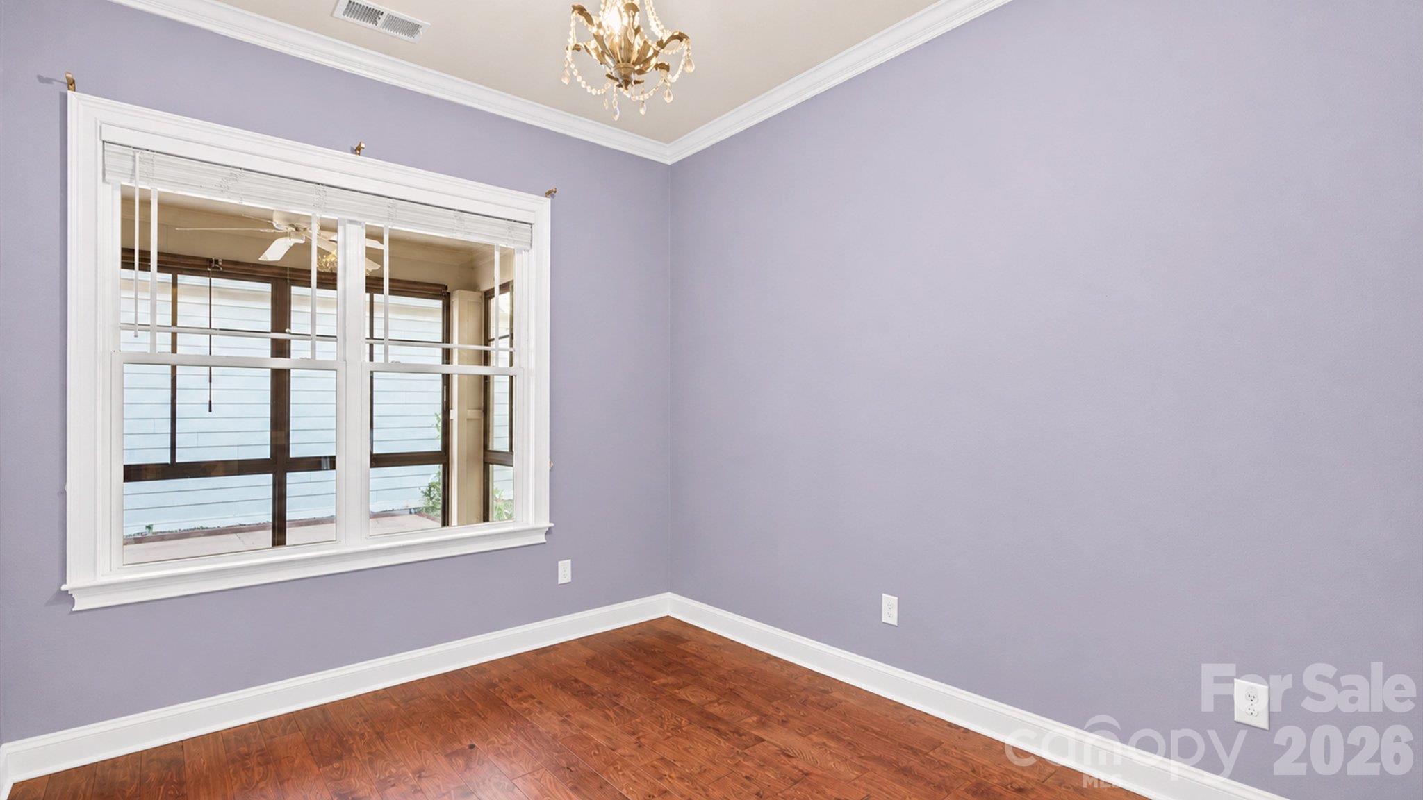 Secondary bedroom with hardwood floors and crown molding - 2050 Laney Pond Road, Matthews
