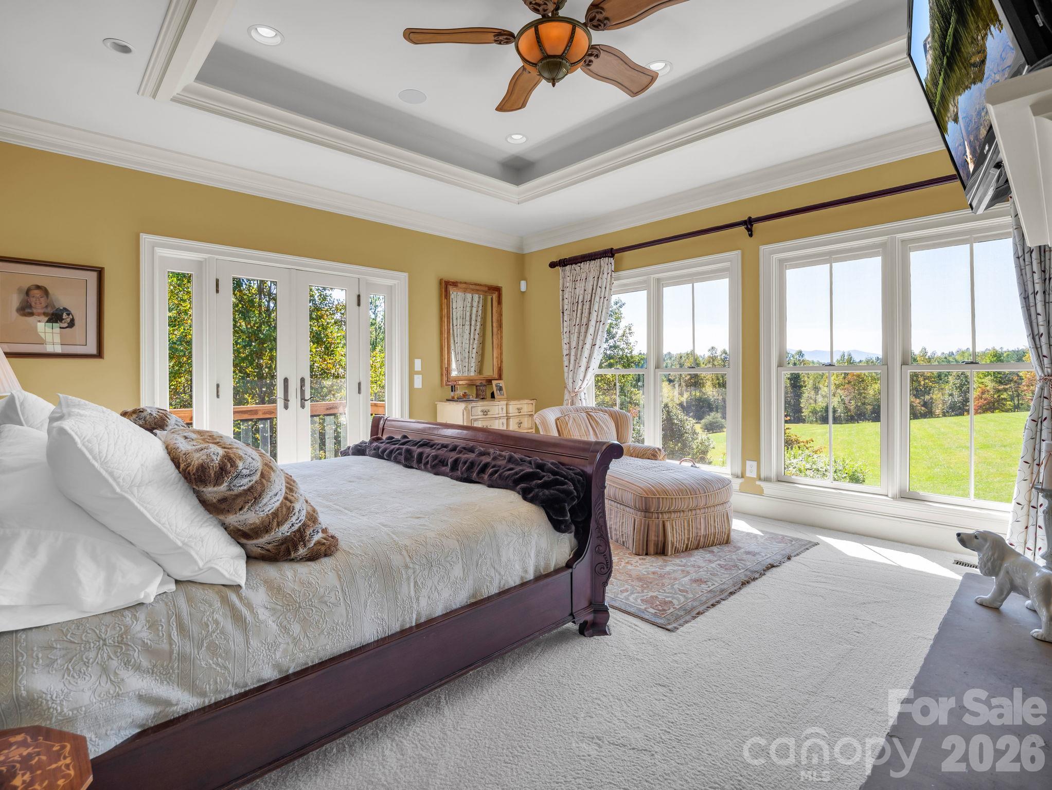 Primary bedroom offers an abundance of natural light overlooking the mountain views - 140 Blazing Star Lane, Mill Spring