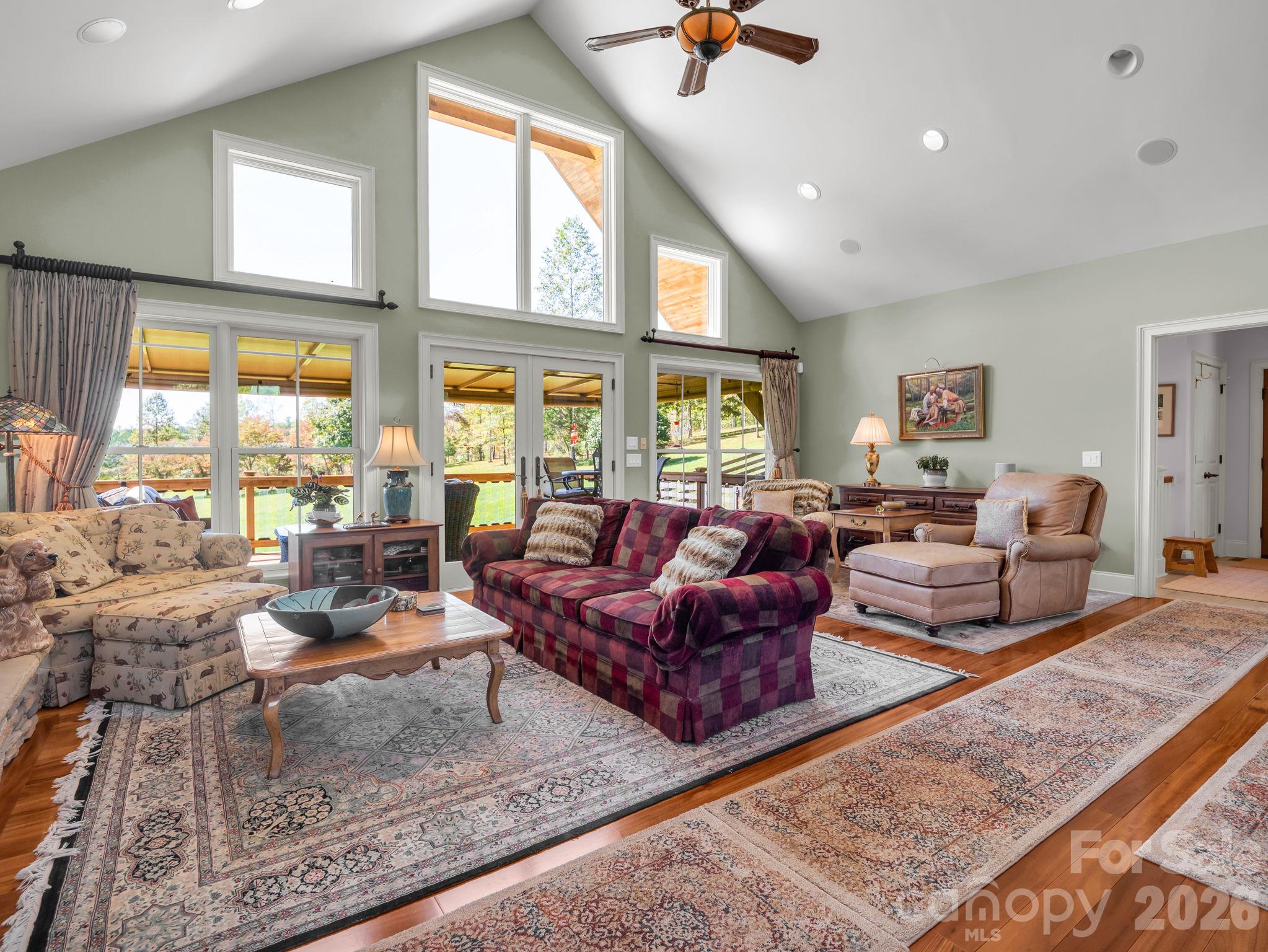 View from breakfast area into the living room with vaulted ceilings, abundant natural light and windows - 140 Blazing Star Lane, Mill Spring