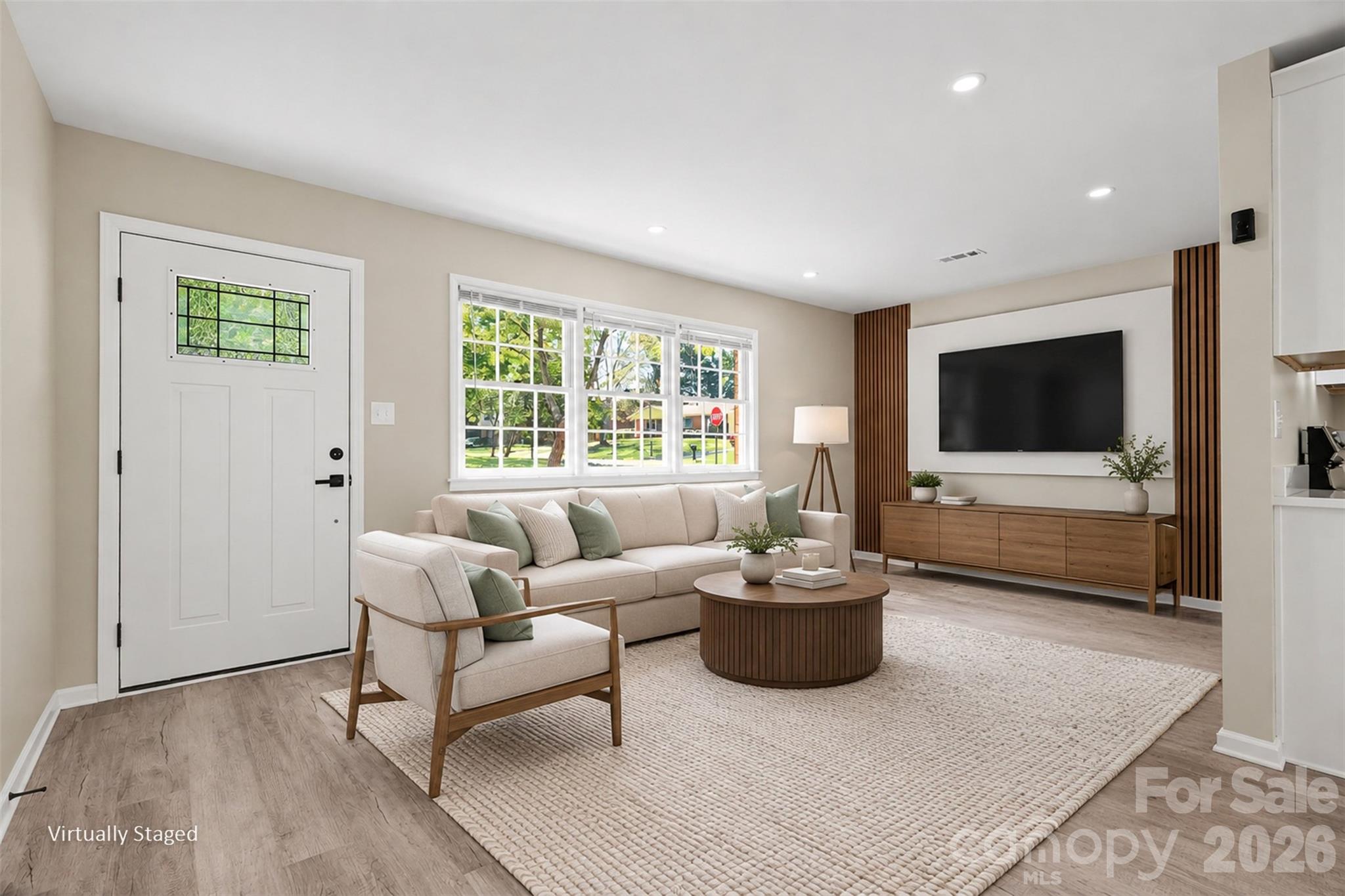Bright living area highlighted by a stylish wood-accent feature wall, ideal for media and TV placement. ( Virtually Staged) - 3801 Hillock Court, Charlotte