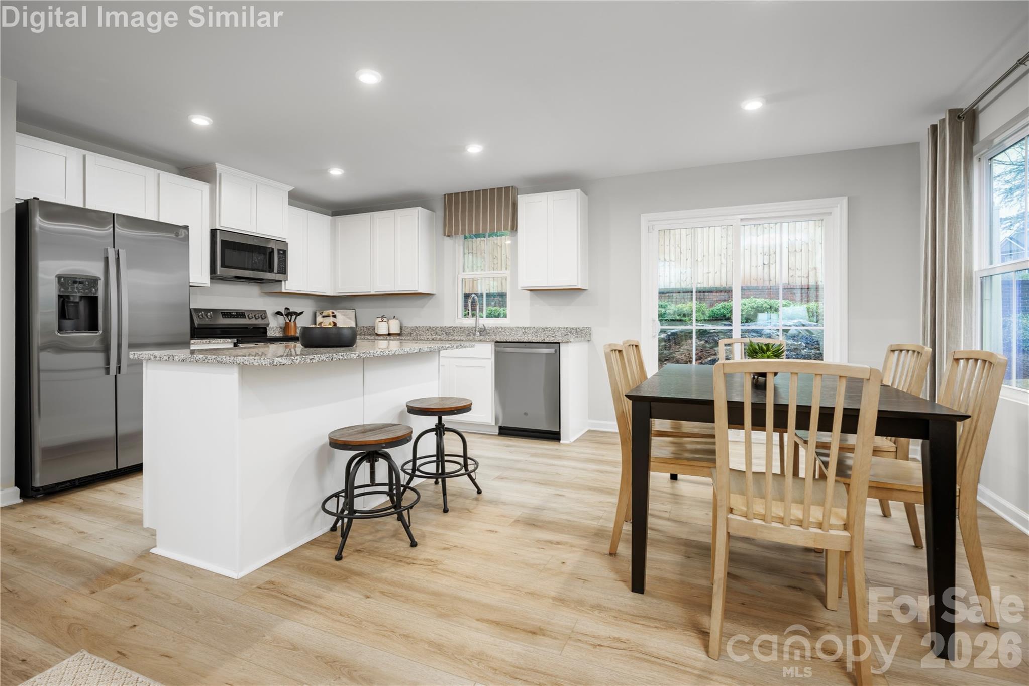 Host with confidence! This spacious kitchen island flows seamlessly into the dining area—ideal for gatherings, family meals, and everyday living. - 5223 Macvittie Lane, Charlotte