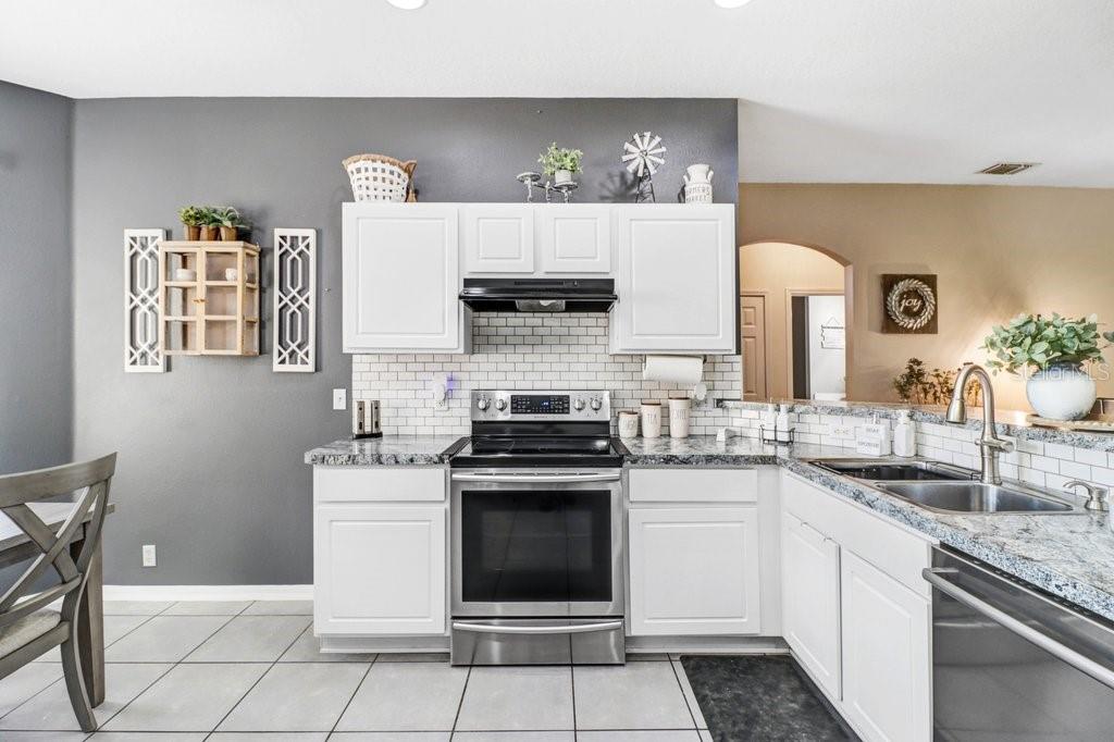 Kitchen with stainless appliances, granite and beautiful backsplash - 3876 WHISTLEWOOD CIR, LAKELAND