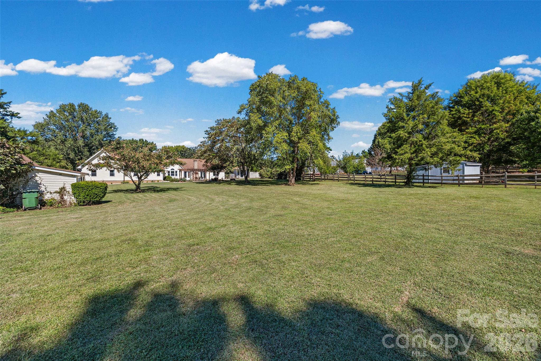View from back of property line to the back of the house- large shed on the left and small shed close to house on the right--large flat and meticulously maintained - 3117 Monte Drive, Monroe