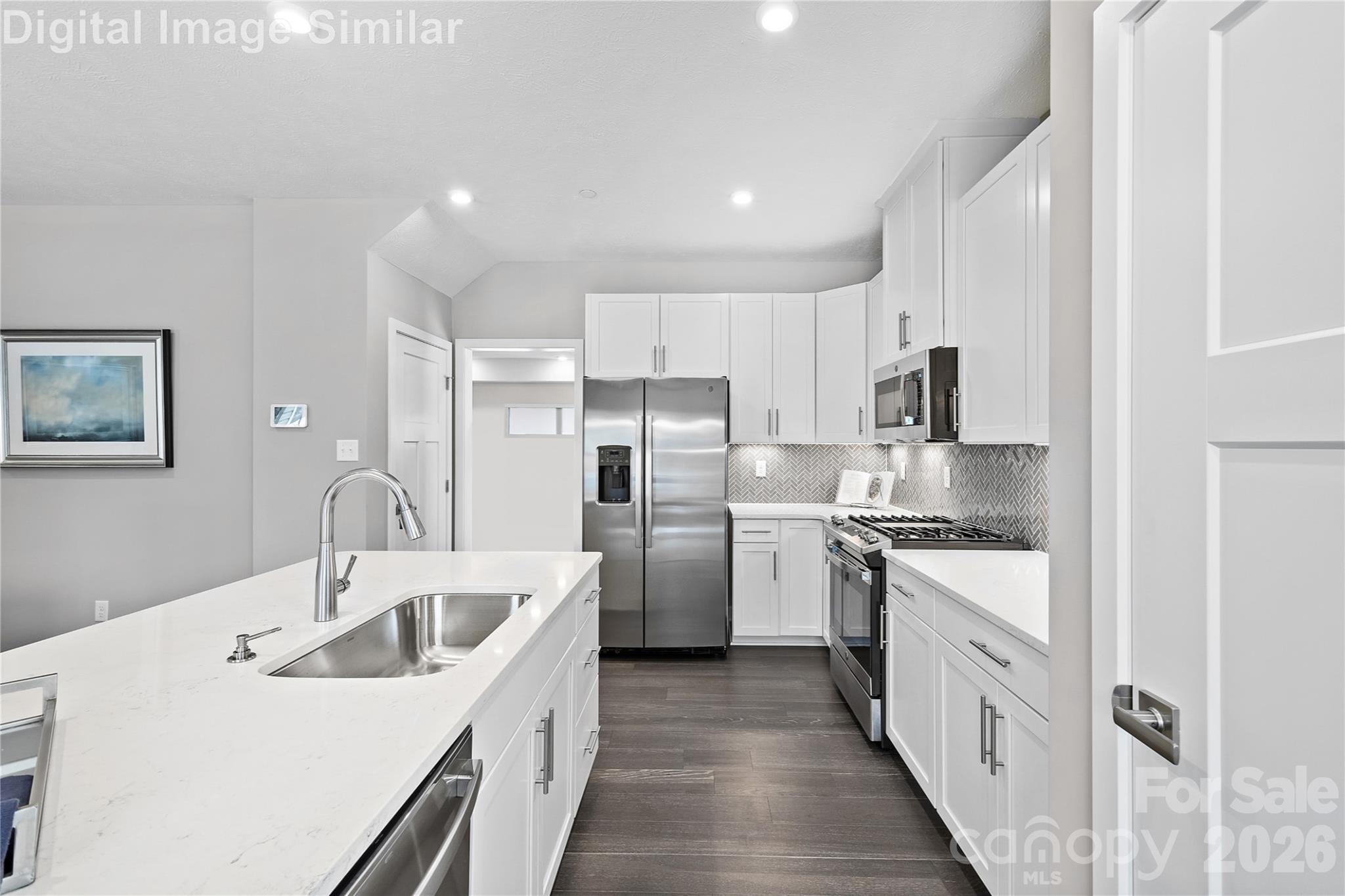 Elegant open-concept kitchen with upscale finishes, tall cabinetry, gleaming countertops and appliances - designed to impress and built to inspire - 11204 Emerson Landing Drive, Charlotte