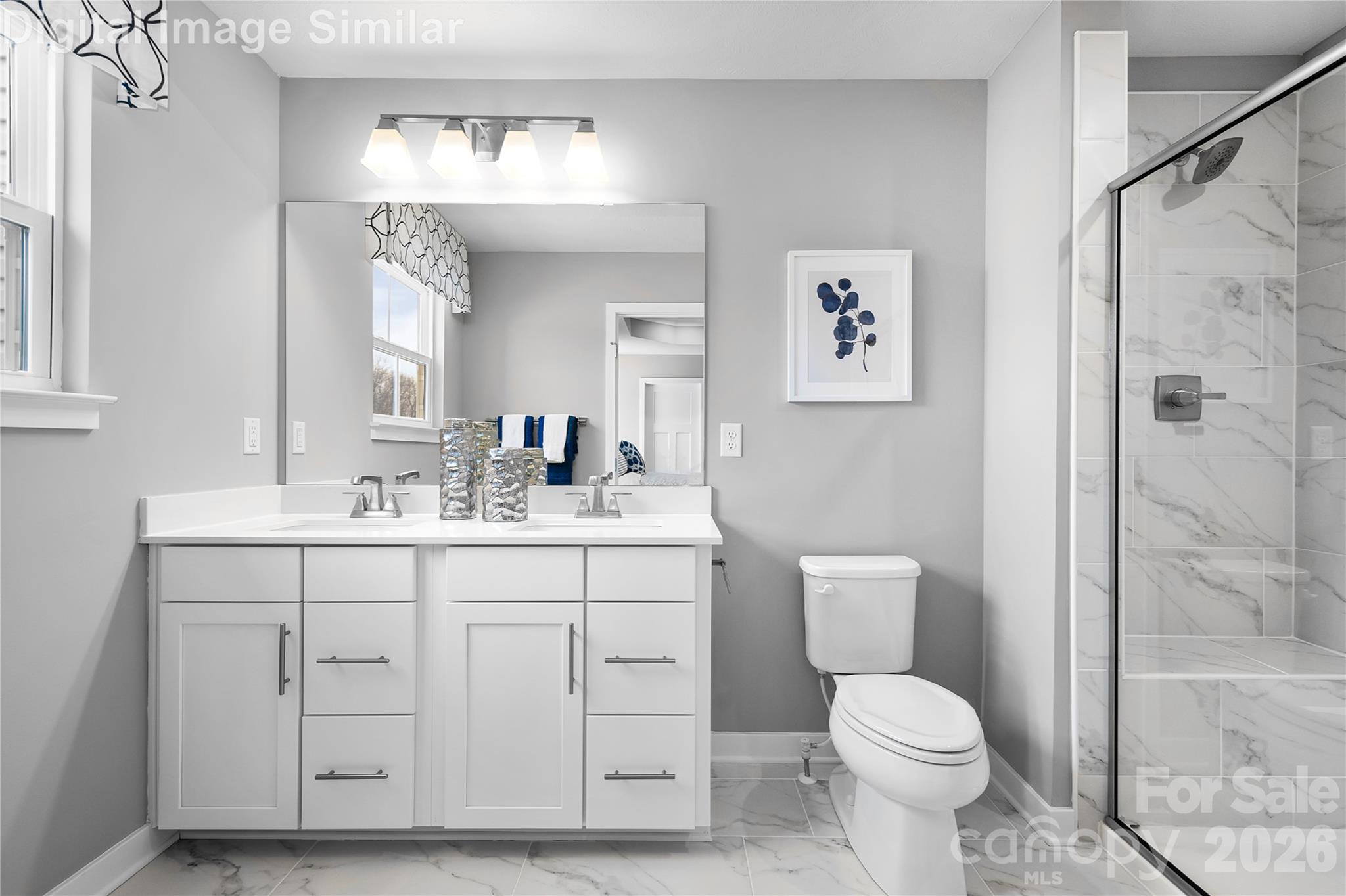 Love where you unwind—this sunlit primary bath features his-and-hers sinks, elegant finishes, and an optional Roman shower with a framed glass door for a spa-like touch. - 11204 Emerson Landing Drive, Charlotte