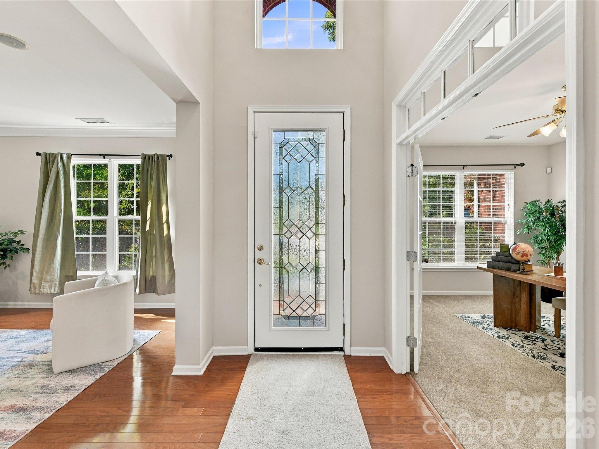Step into this bright foyer featuring gleaming hardwood floors, elegant crown molding, and an open, light-filled design that creates a warm and welcoming first impression. - 1788 Oakmont Drive, Denver