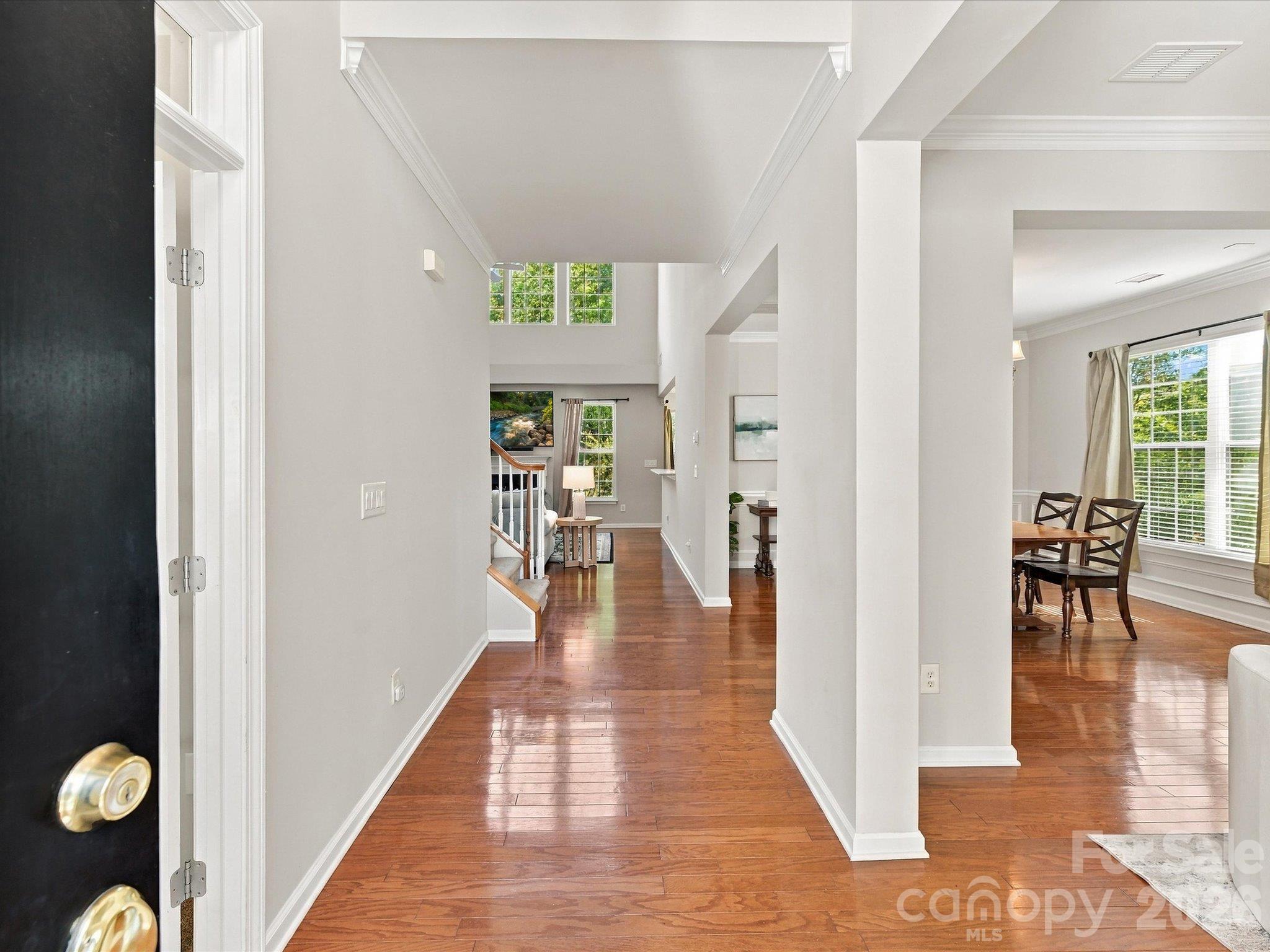 Step into this bright foyer featuring gleaming hardwood floors, elegant crown molding, and an open, light-filled design that creates a warm and welcoming first impression. - 1788 Oakmont Drive, Denver