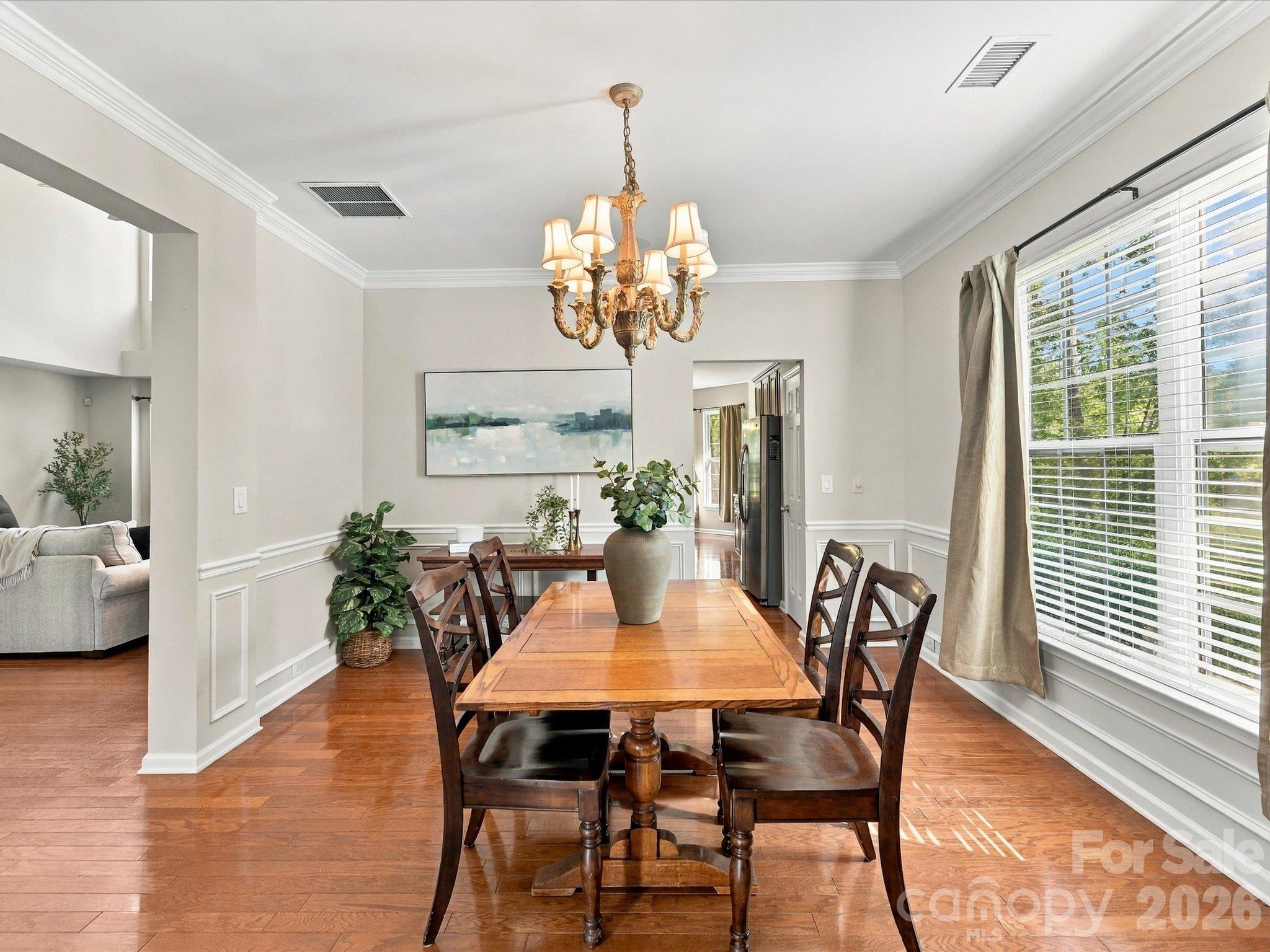 Formal dining room with hardwood floors, classic wainscoting, and abundant natural light, making it the perfect space for hosting holiday gatherings and dinner parties. - 1788 Oakmont Drive, Denver