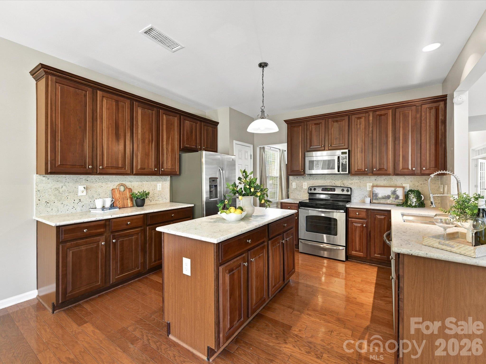 Inviting kitchen with plentiful cabinetry, brand-new gorgeous granite countertops, a center island, stainless steel appliances, and a layout that seamlessly blends style and functionality. - 1788 Oakmont Drive, Denver