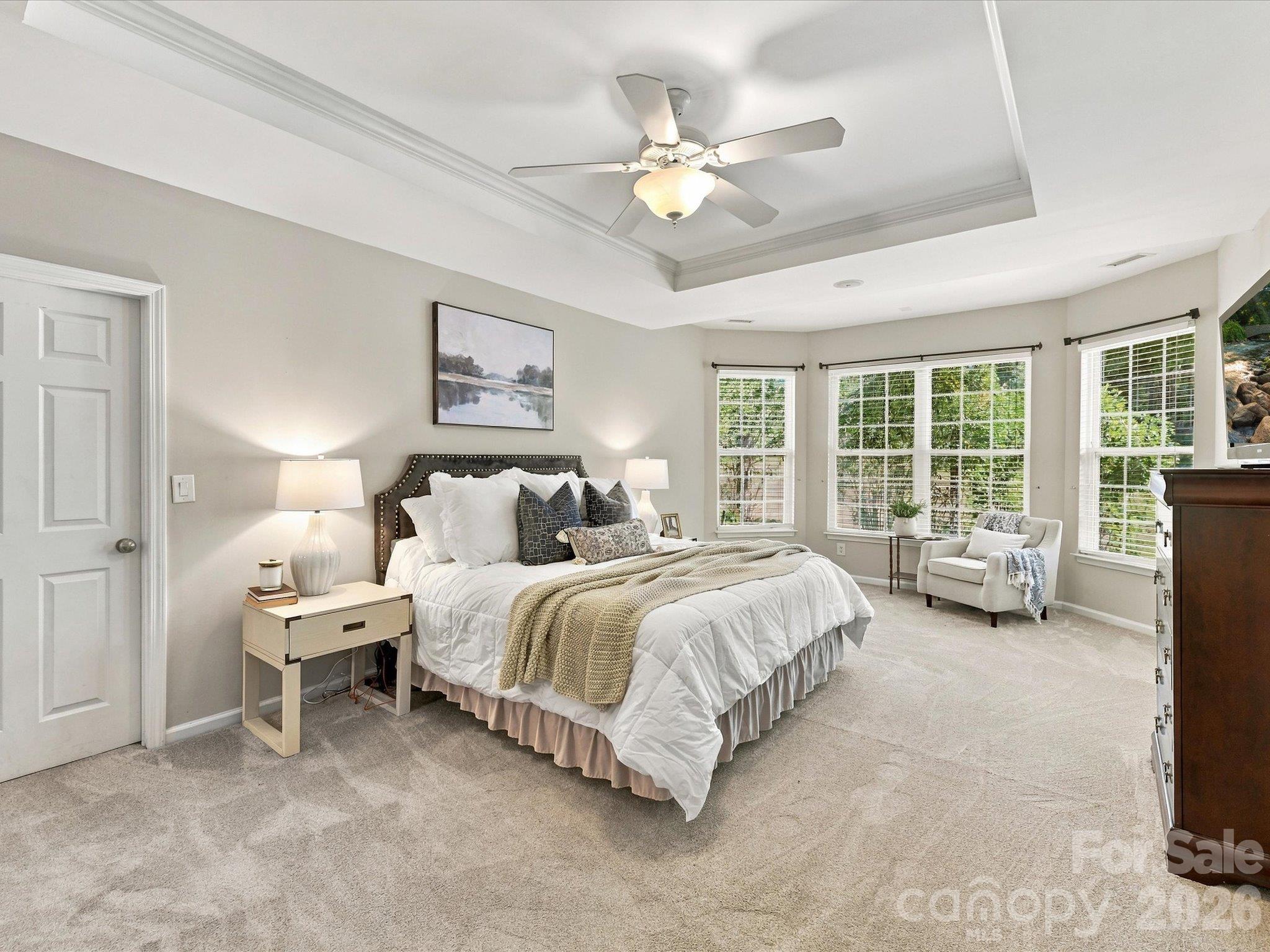 Spacious primary suite featuring a tray ceiling, abundant natural light, a cozy sitting area, and plenty of room to create your own private retreat. - 1788 Oakmont Drive, Denver