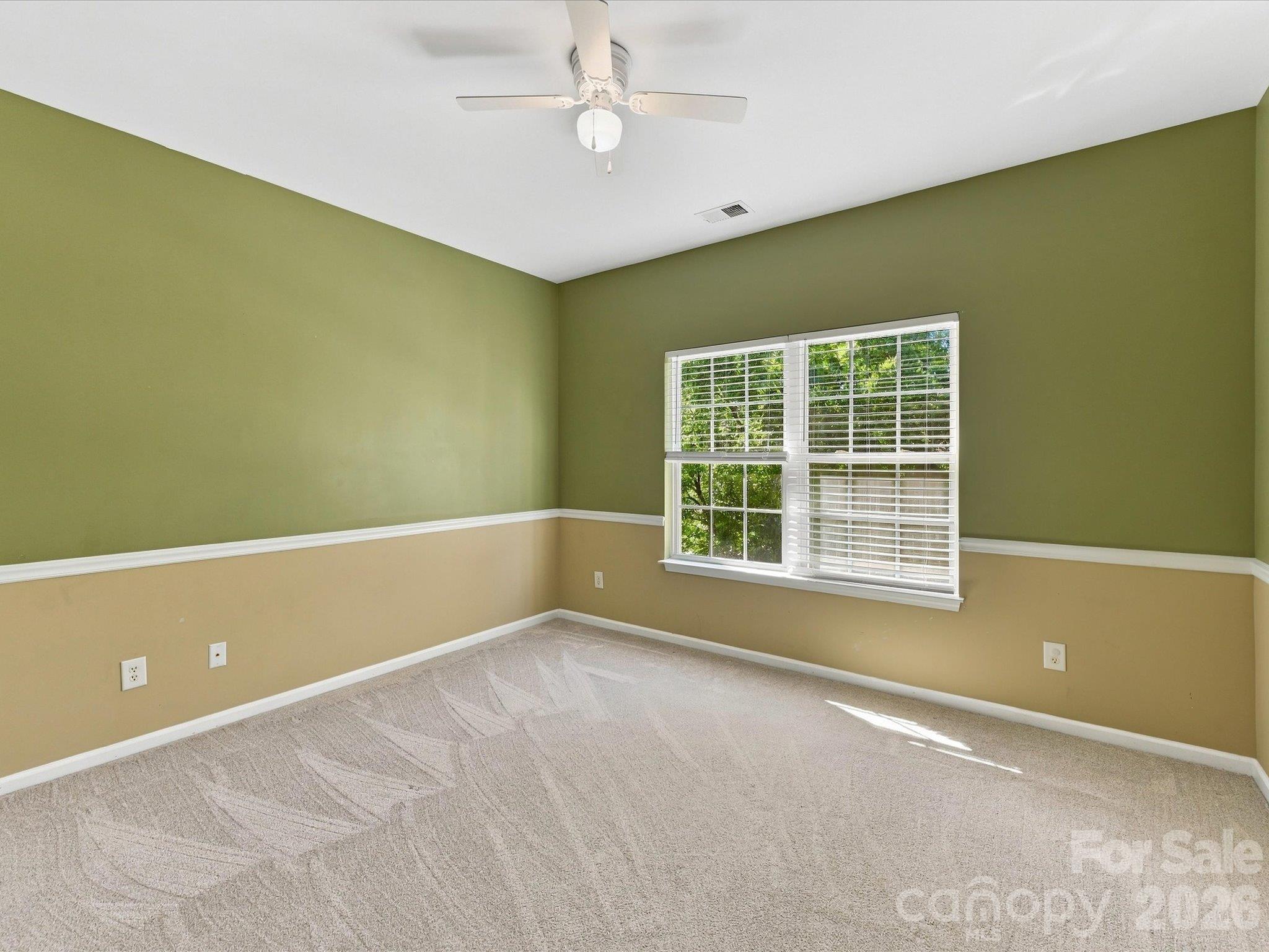 This spacious secondary bedroom offers ample room for furnishings, abundant natural light, and a comfortable layout ideal for family or guests. - 1788 Oakmont Drive, Denver